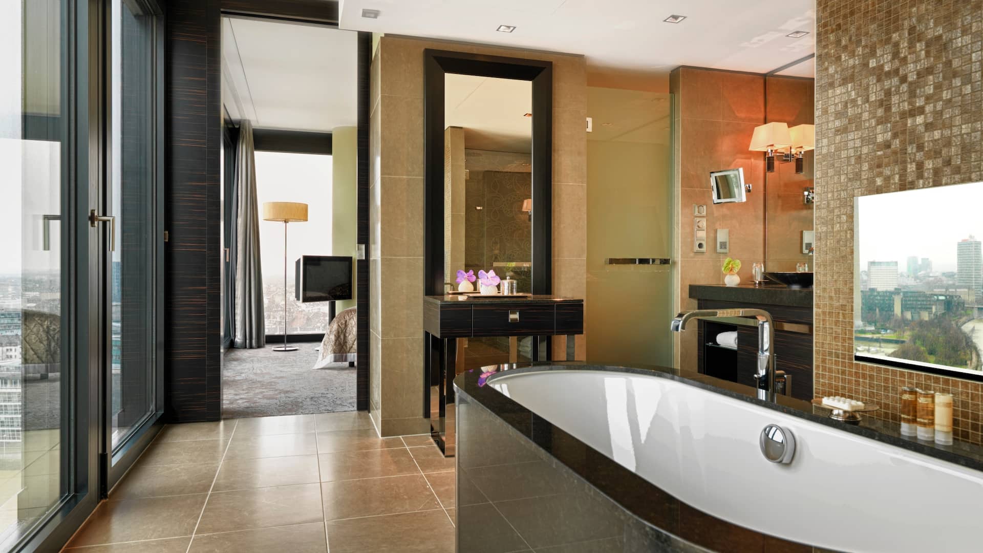 Executive Suite bathroom at Hyatt Regency Dusseldorf, bathtub, make up mirror, hall to bedroom and floor to ceiling windows