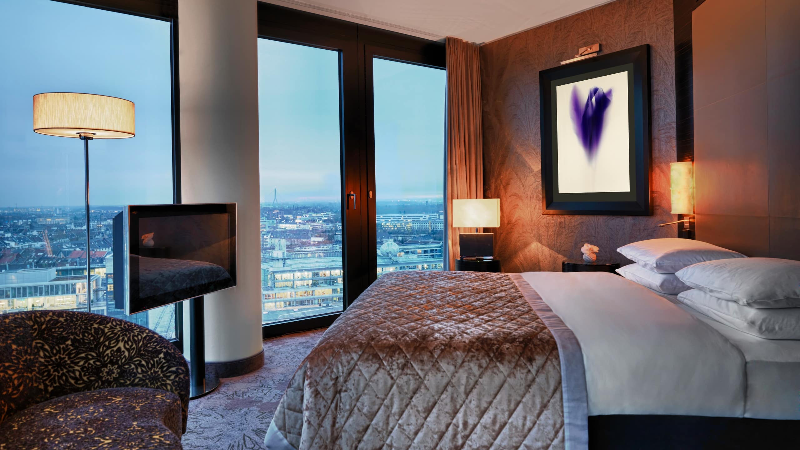 Executive Suite at Hyatt Regency Dusseldorf, a king bed, a small couch, TV and great view of the city of Dusseldorf