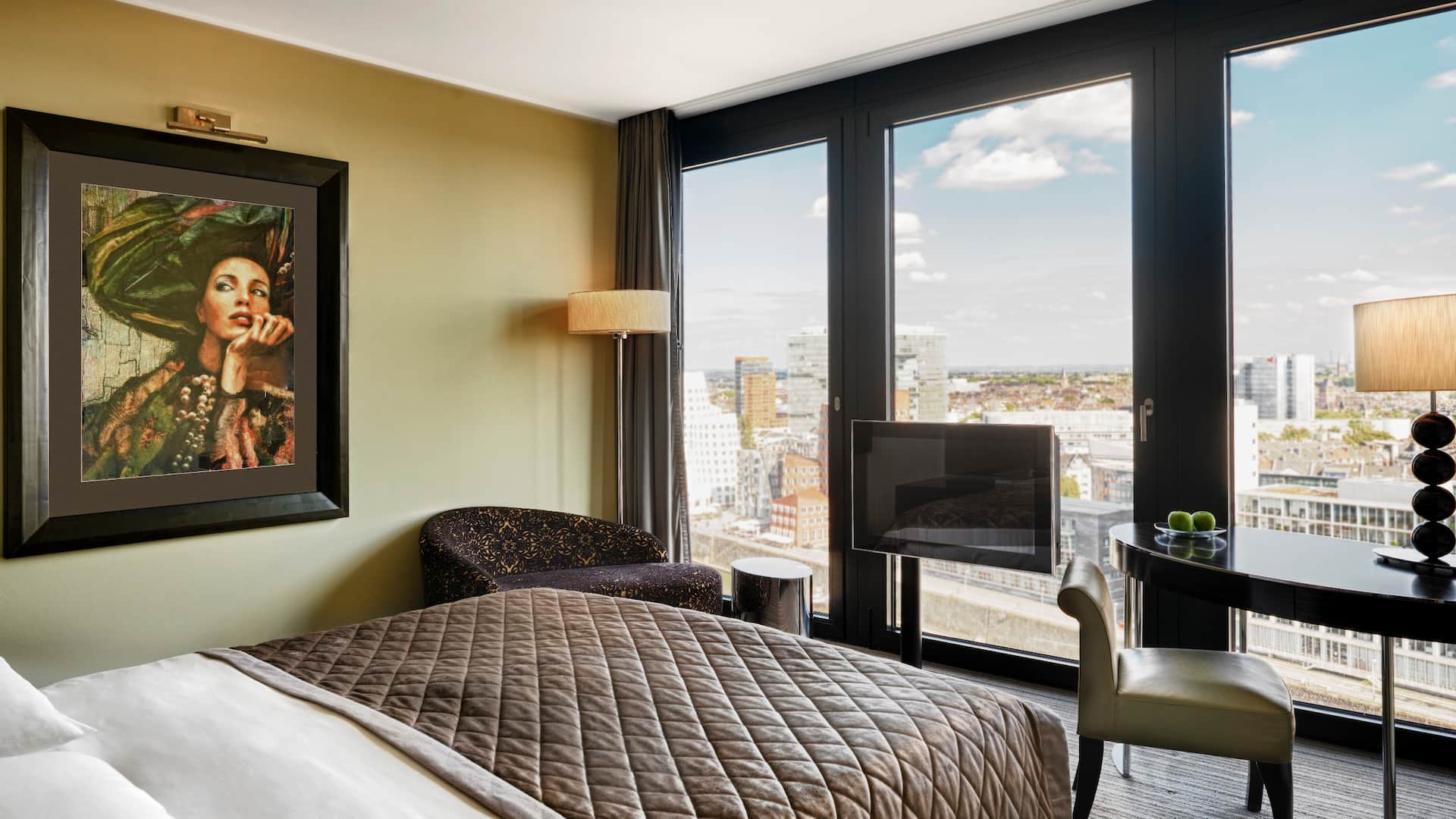 View King Room at Hyatt Regency Dusseldorf, with desk, TV, small couch, floor to ceiling windows with view of the MediaHarbor
