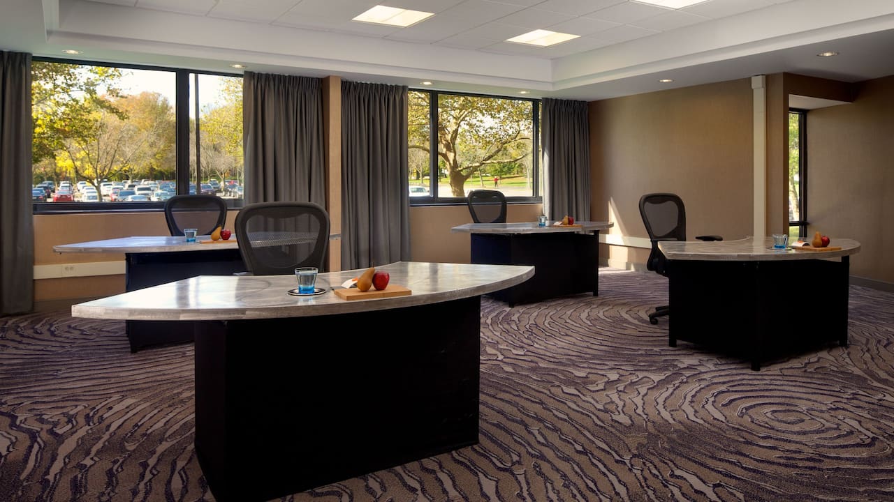 Four tables with office chairs in hotel meeting room
