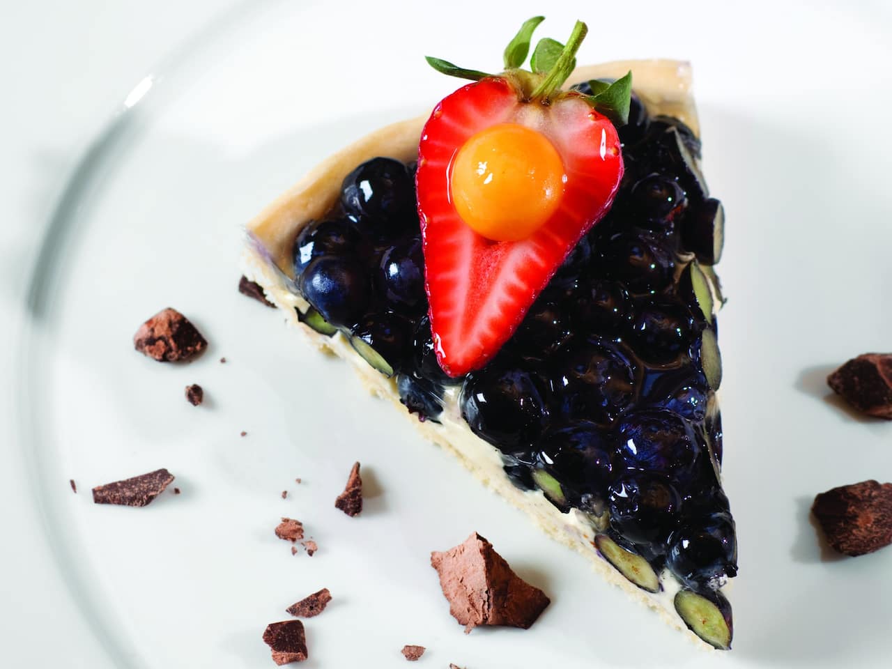 A slice of pie topped with a strawberry