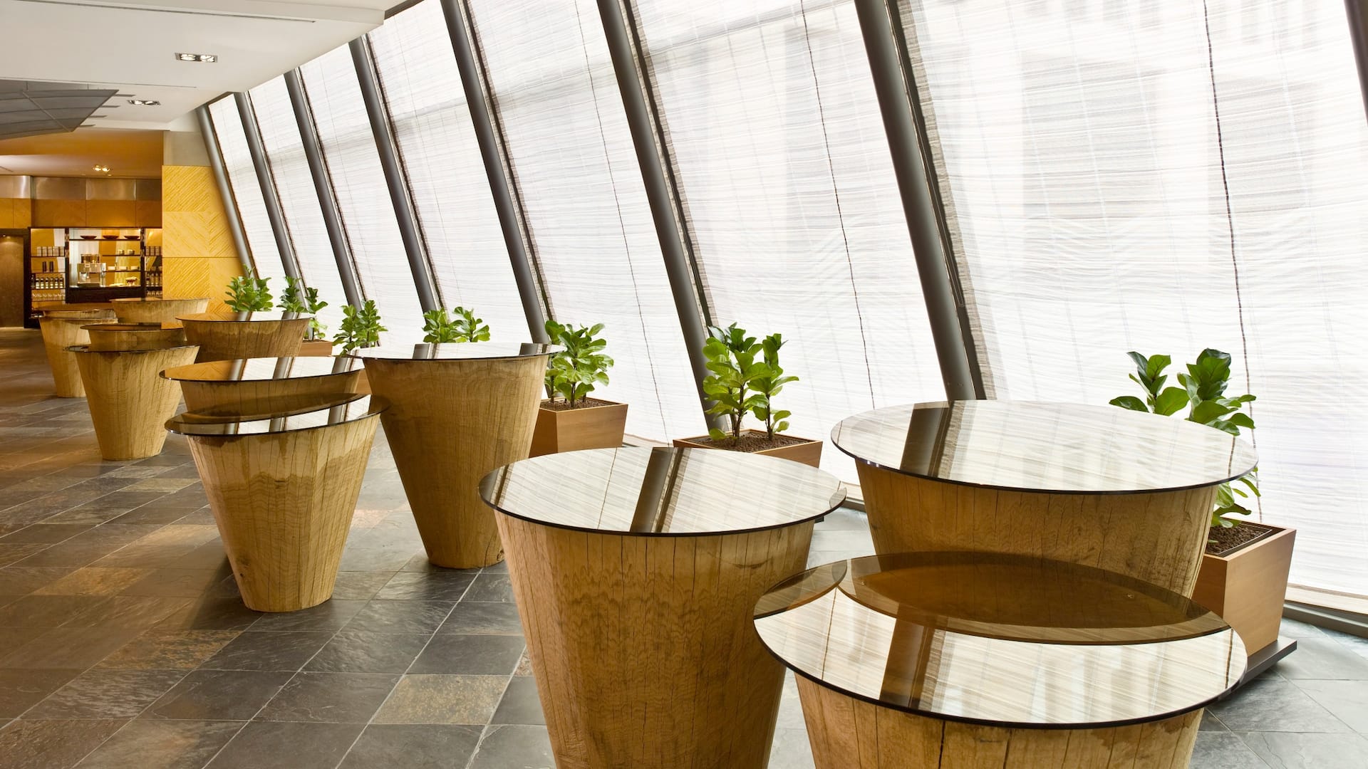 Foyer with conical wood tables in front of the Hyatt Regency Mainz ballroom