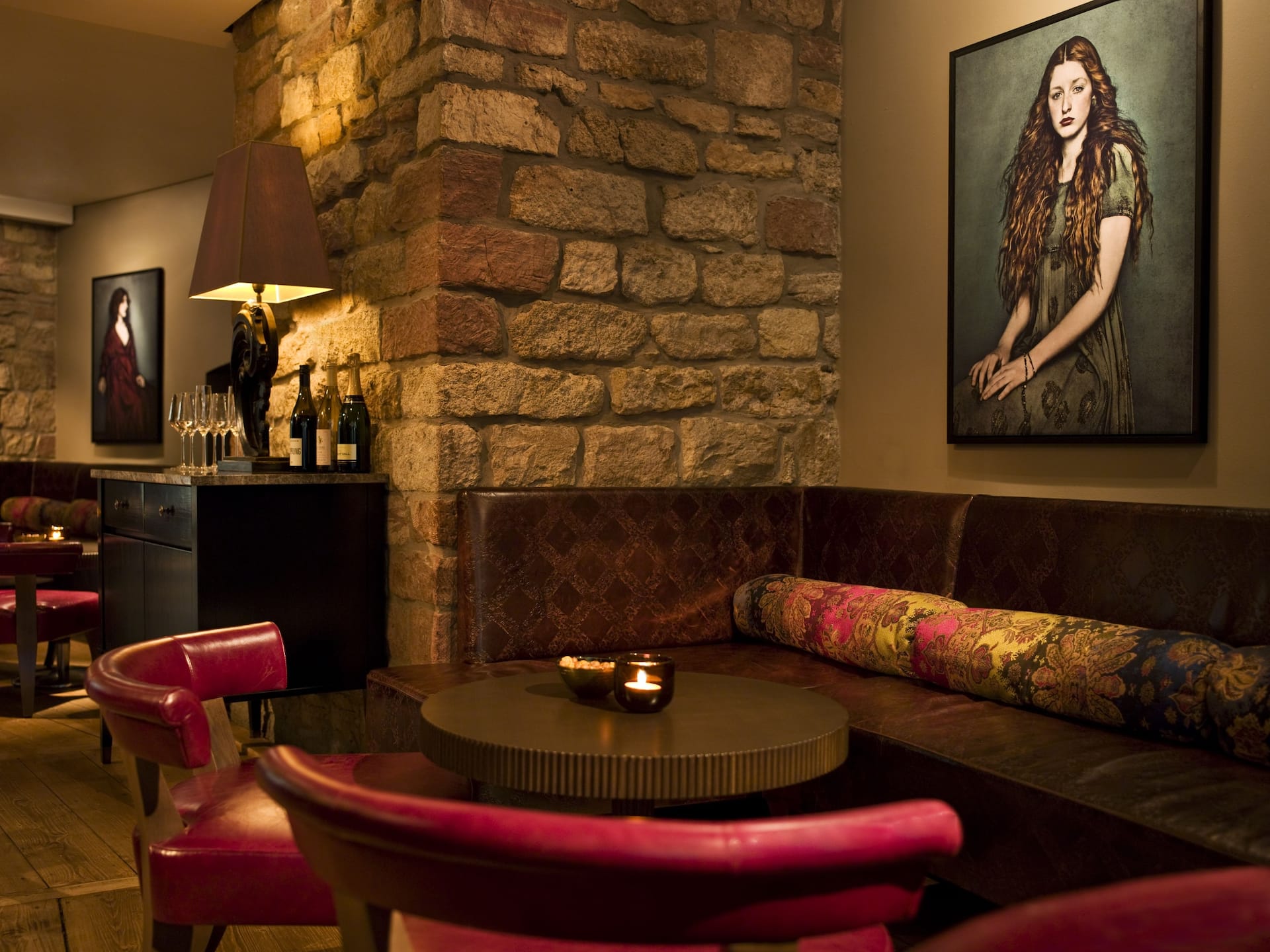 Cozy seating area with round table and painting on the wall at Malakoff bar