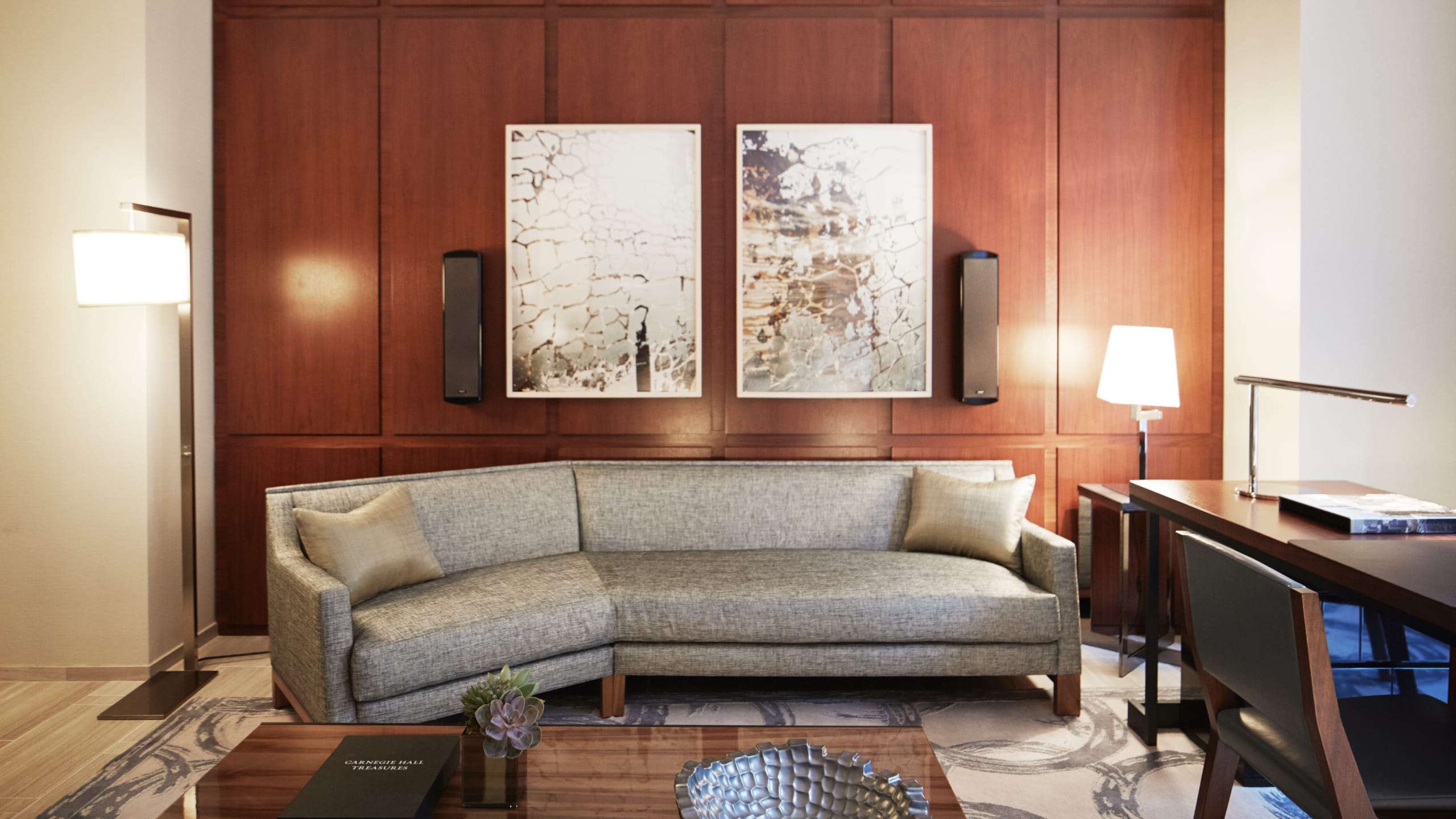 3 из 7 Seating area with a sofa, writing desk and artwork on a wood wall