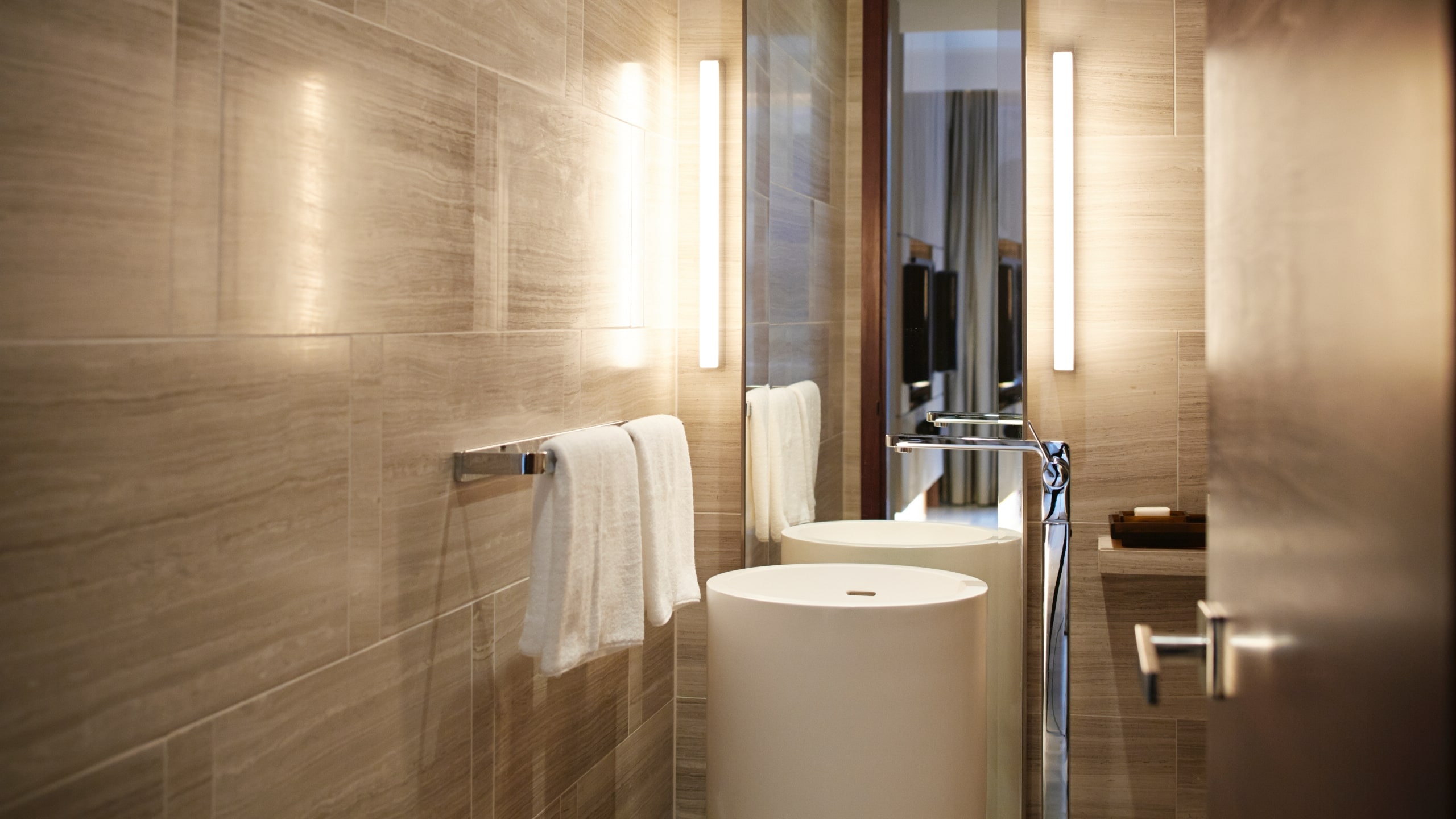 5 из 7 A half bath with a modern sink and two towels hung on a wrack