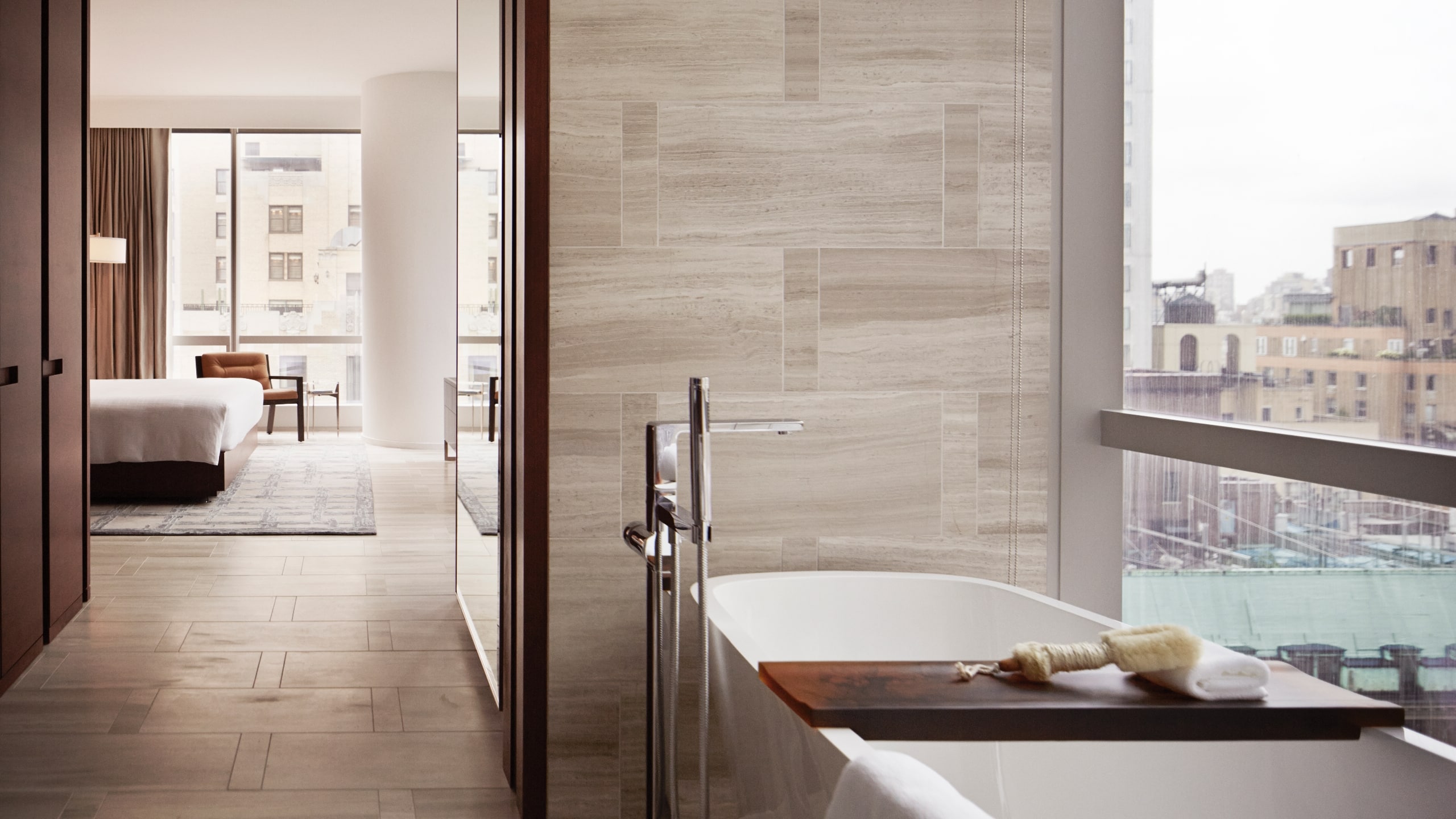 View from the bathroom into the suite with a large soaking tub in the foreground and the bed in the background