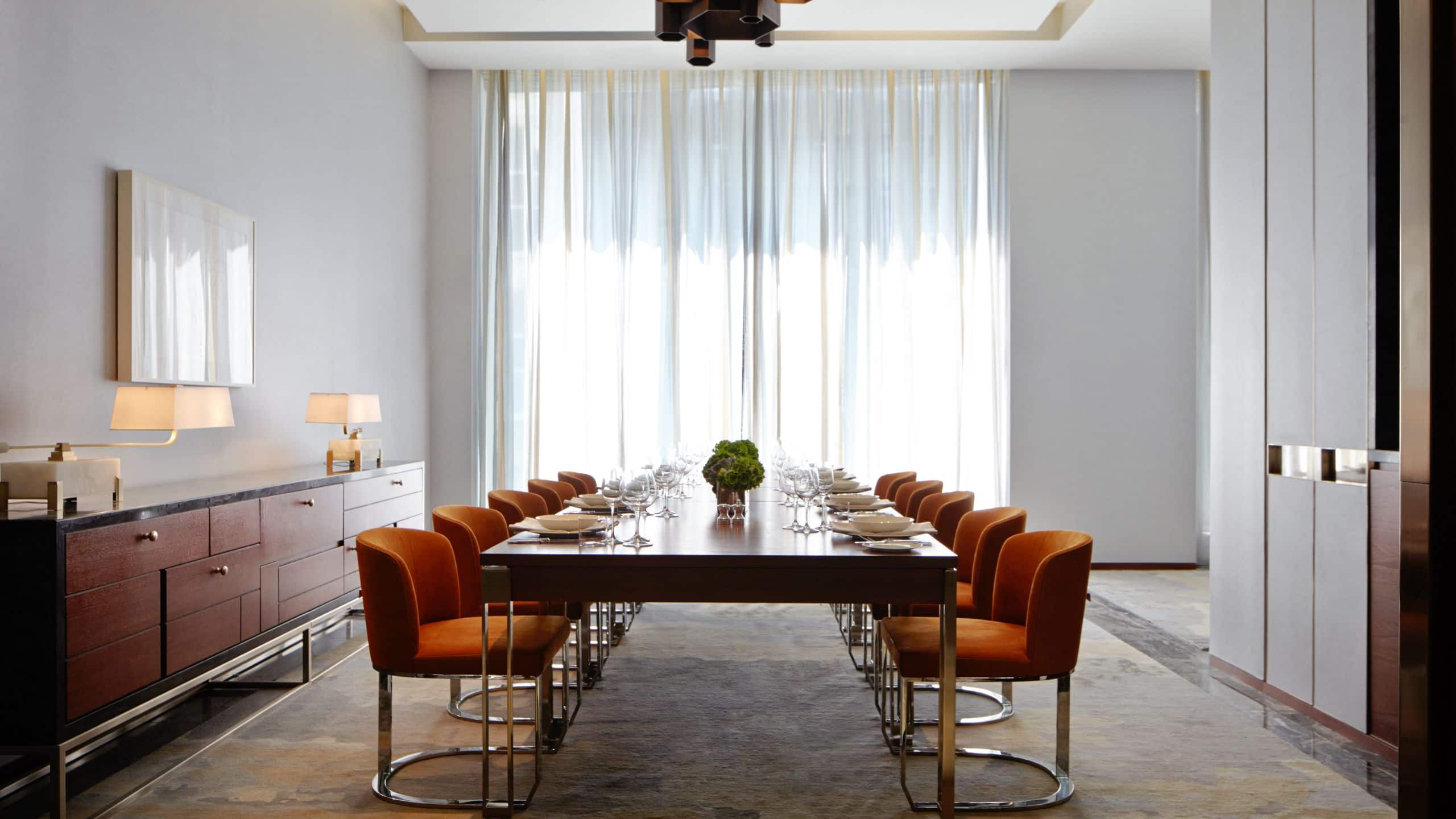 3 of 4 Dining space with a large table and many chairs with floor to ceiling window in the background