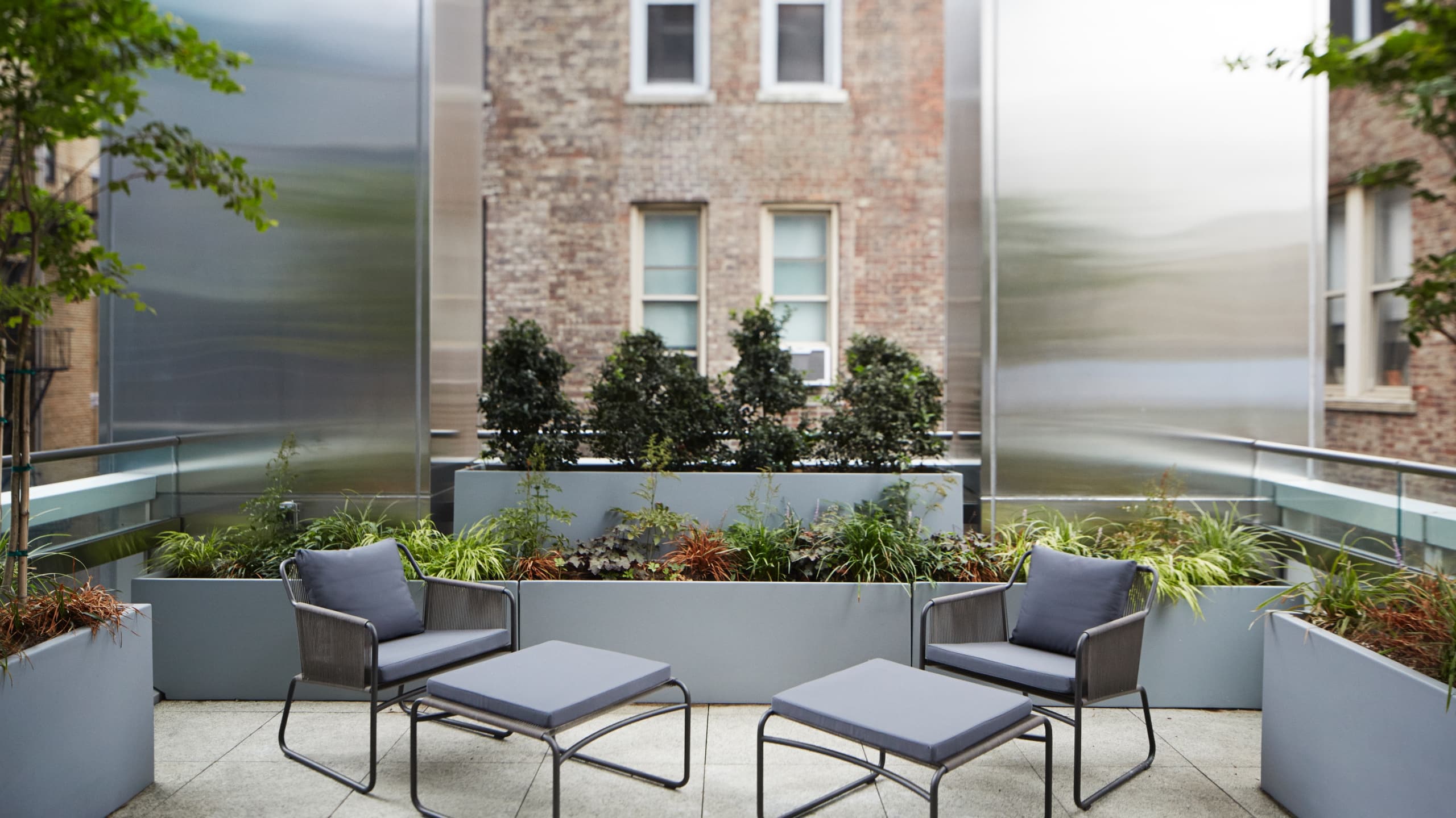 4 из 6 Outdoor terrace with two lounge chairs and greenery in planters