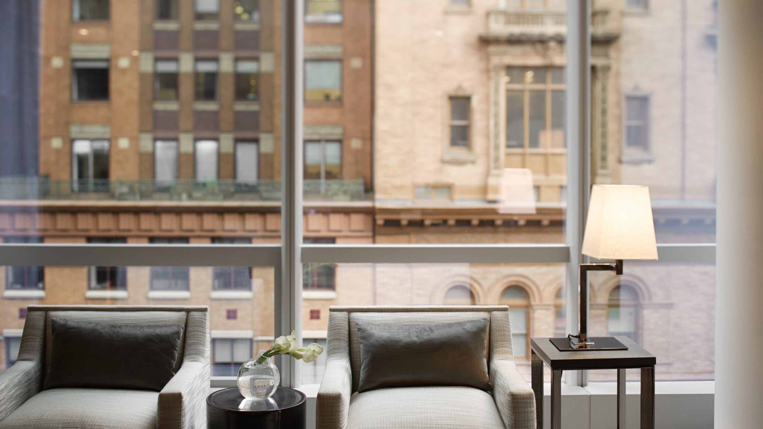 6 of 9 Views of the city from floor to ceiling windows with two armchairs in the foreground