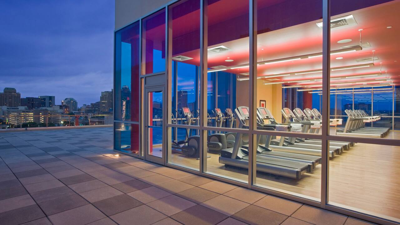 Exterior view looking into the fitness center at dusk