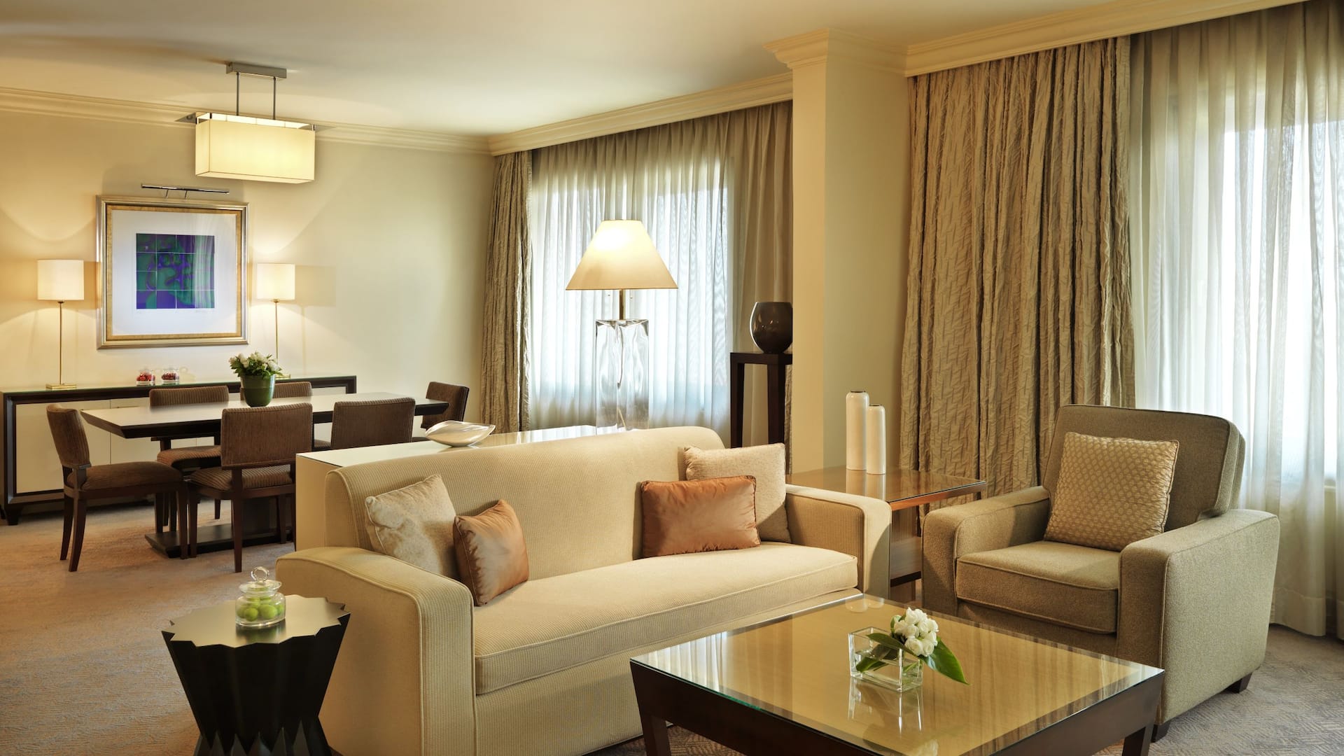 Executive Suite at the luxury Istanbul hotel, Grand Hyatt Istanbul, featuring a cozy cream-toned living room with dim lighting, plush seating, and a dining area in the background.