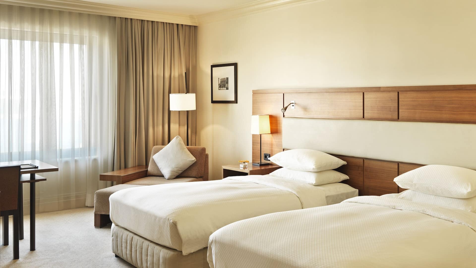 1 de 5 2 Twin Bed standard room at Grand Hyatt Istanbul, featuring soft colors, a shared headboard, a working space, and a reading sofa.