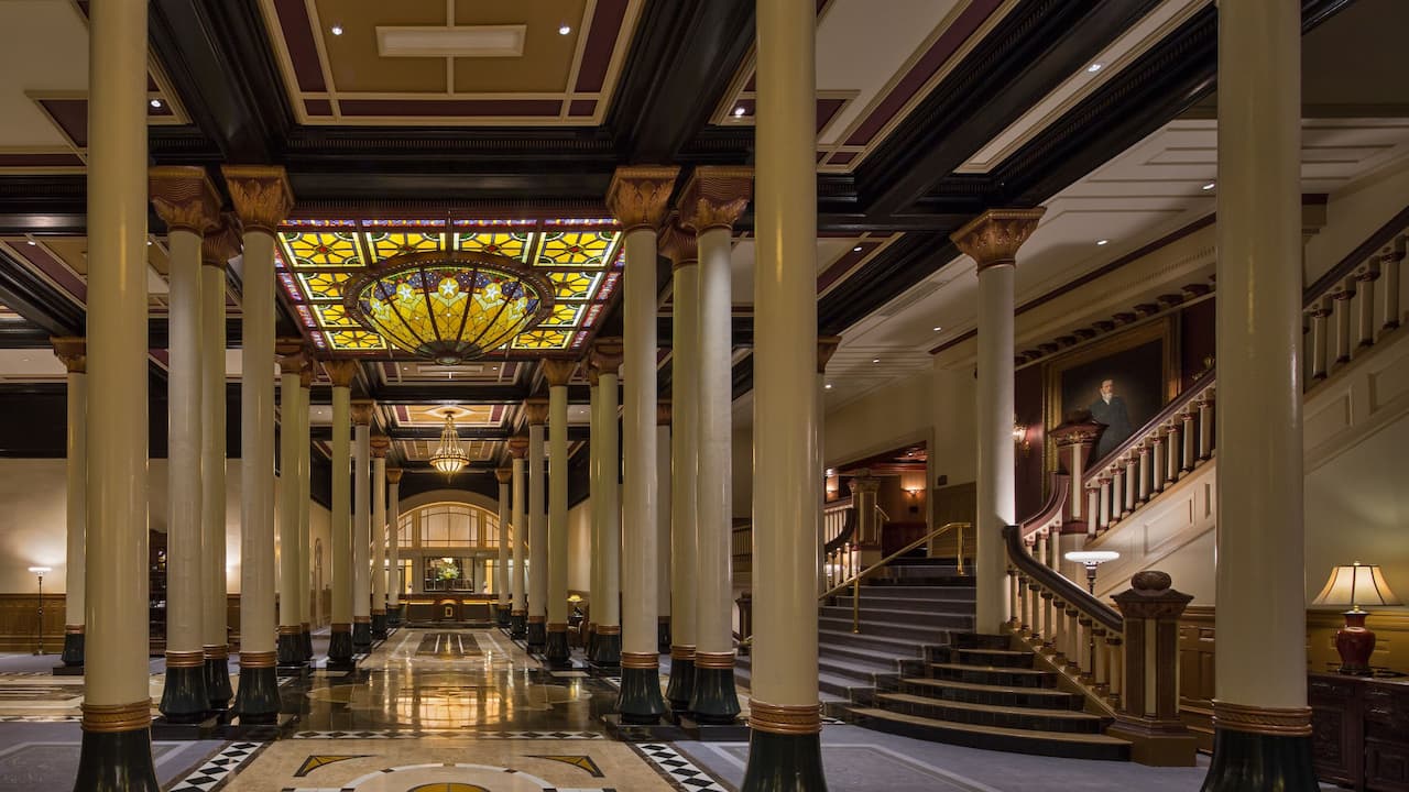Lobby with grand staircase and stained glass ceiling