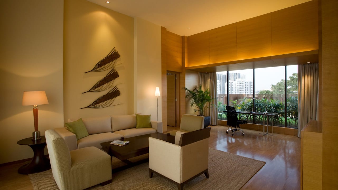 Hyatt Suite with wooden flooring and almond painted walls, having an outdoor view of trees at distant and blue sky