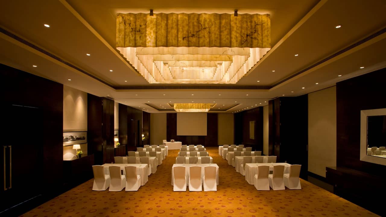 Class Room setup in an indoor banquet hall having warm ambient light for conference