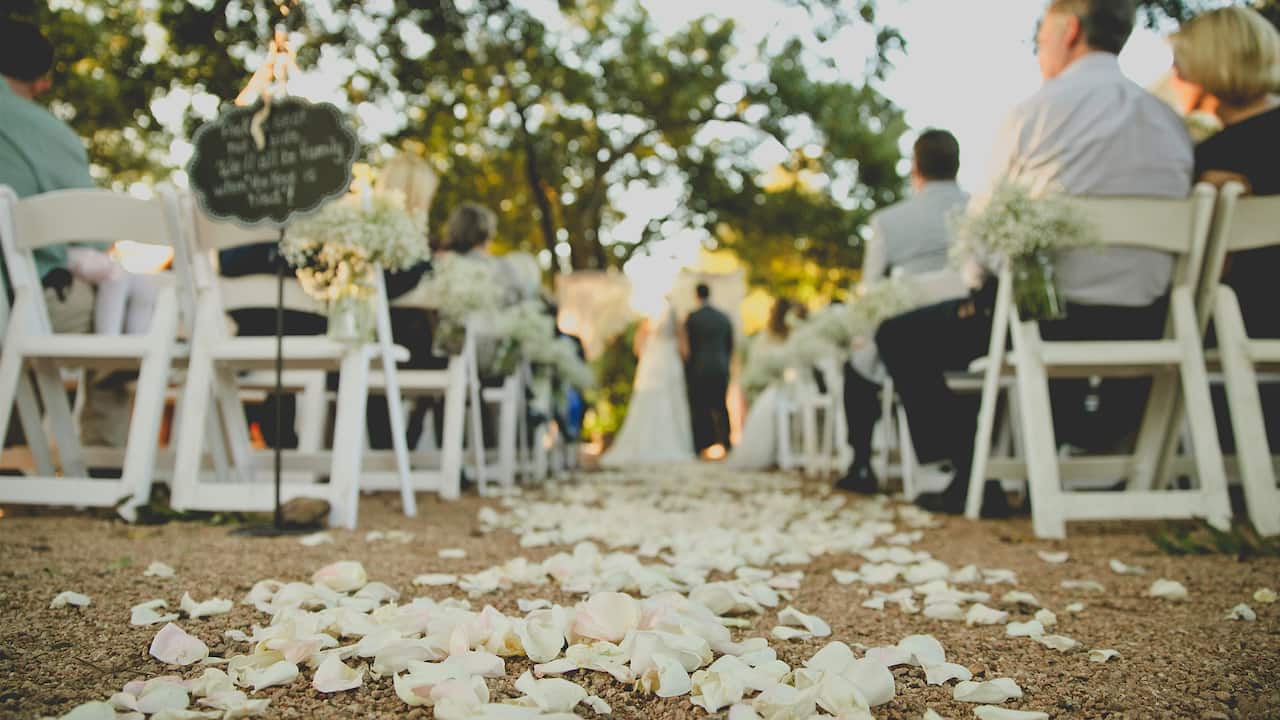 Outdoor wedding ceremony with bride, groom, and guests