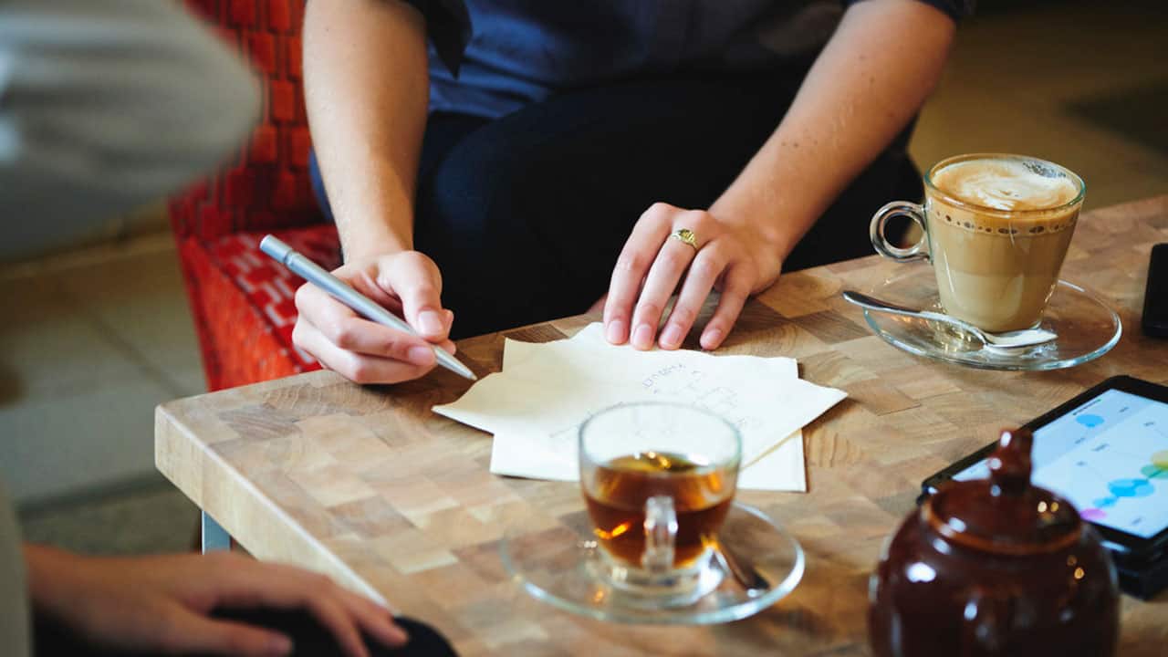 Hyatt Centric Women in Cafe Writing on Napkin