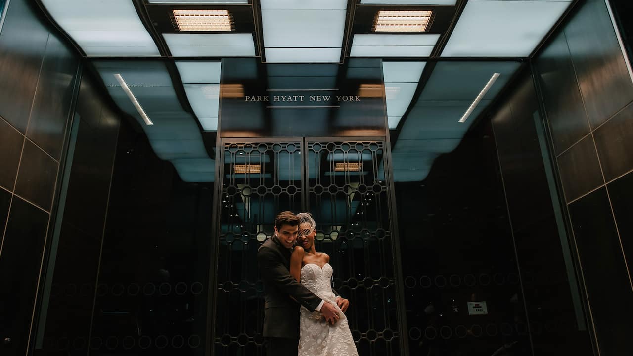 Wedding couple in front of hotel entrance