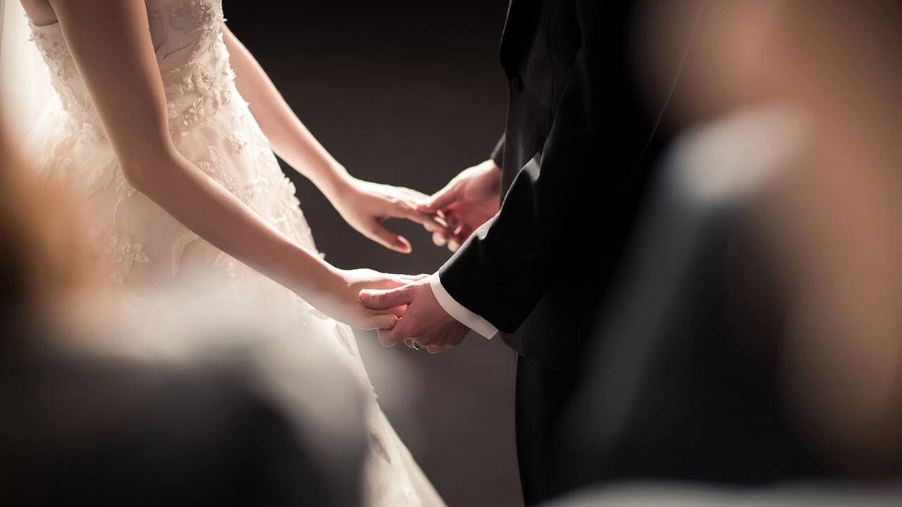 A couple holding hands at their wedding at Hyatt House Salt Lake City/Sandy Utah hotel