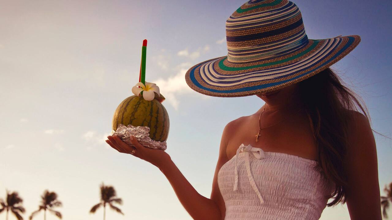 Hotel guest with coconut drink enjoying Waikiki Beach