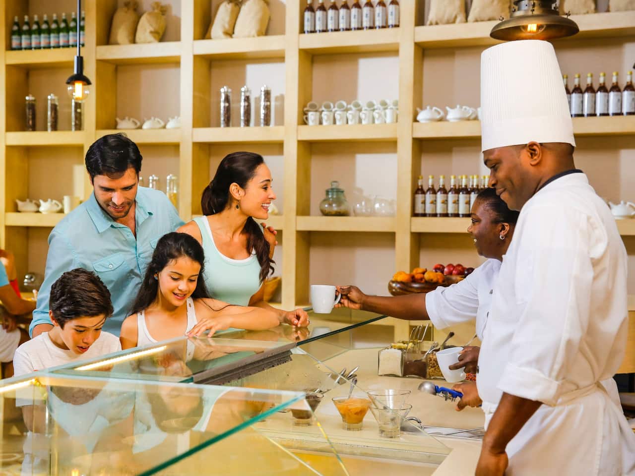Family getting coffee and food from staff at BiteZ Deli & Café at Hyatt Ziva Rose Hall 