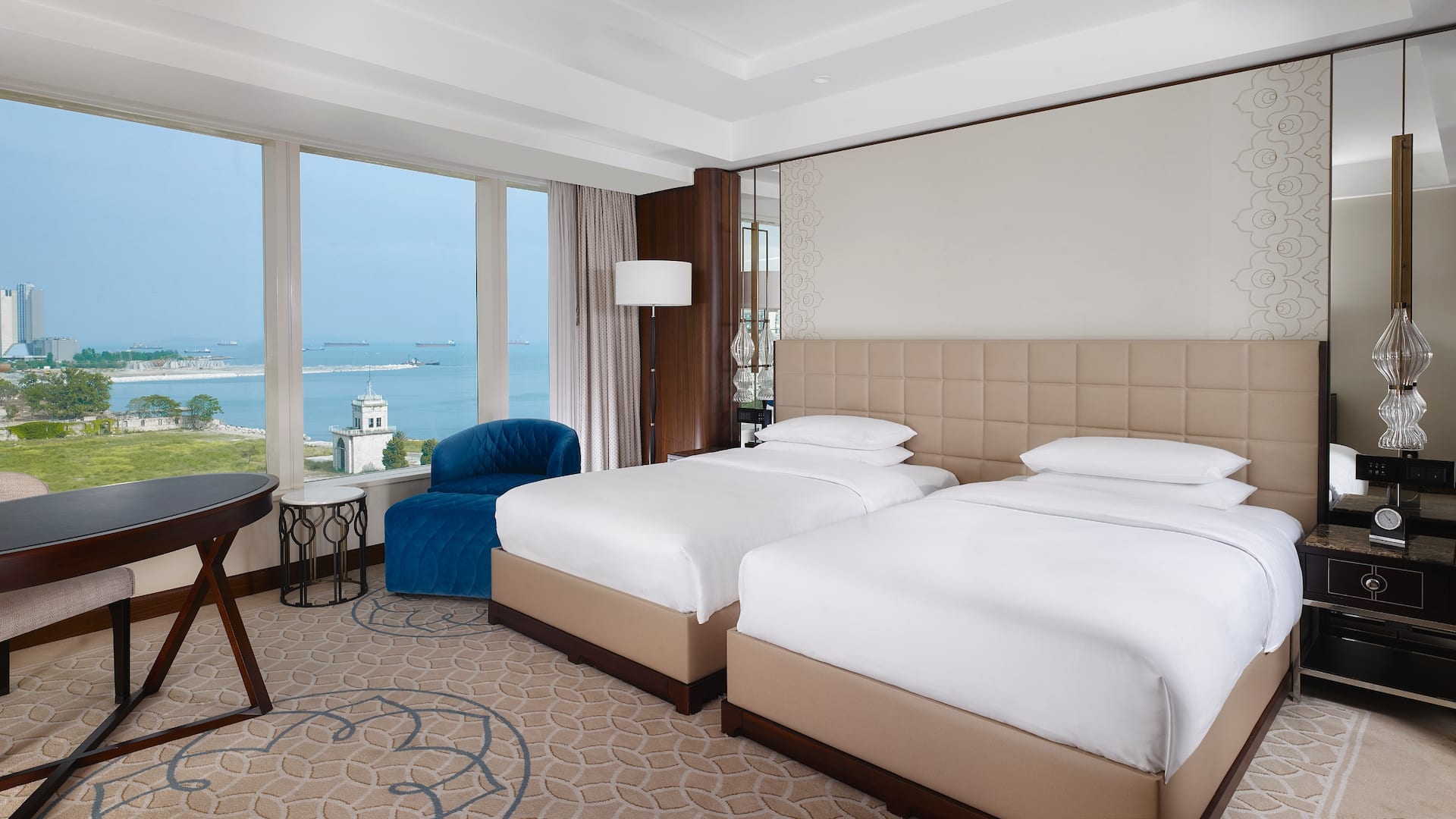 2 Twin Beds with Sea View and Club Access at Hyatt Regency Istanbul Ataköy, featuring a tufted beige headboard, plush blue armchair, and panoramic sea views.