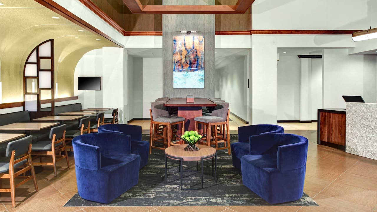 Lobby seating area with chairs, tables, and mural at Hyatt Place Atlanta / Alpharetta / Windward Parkway