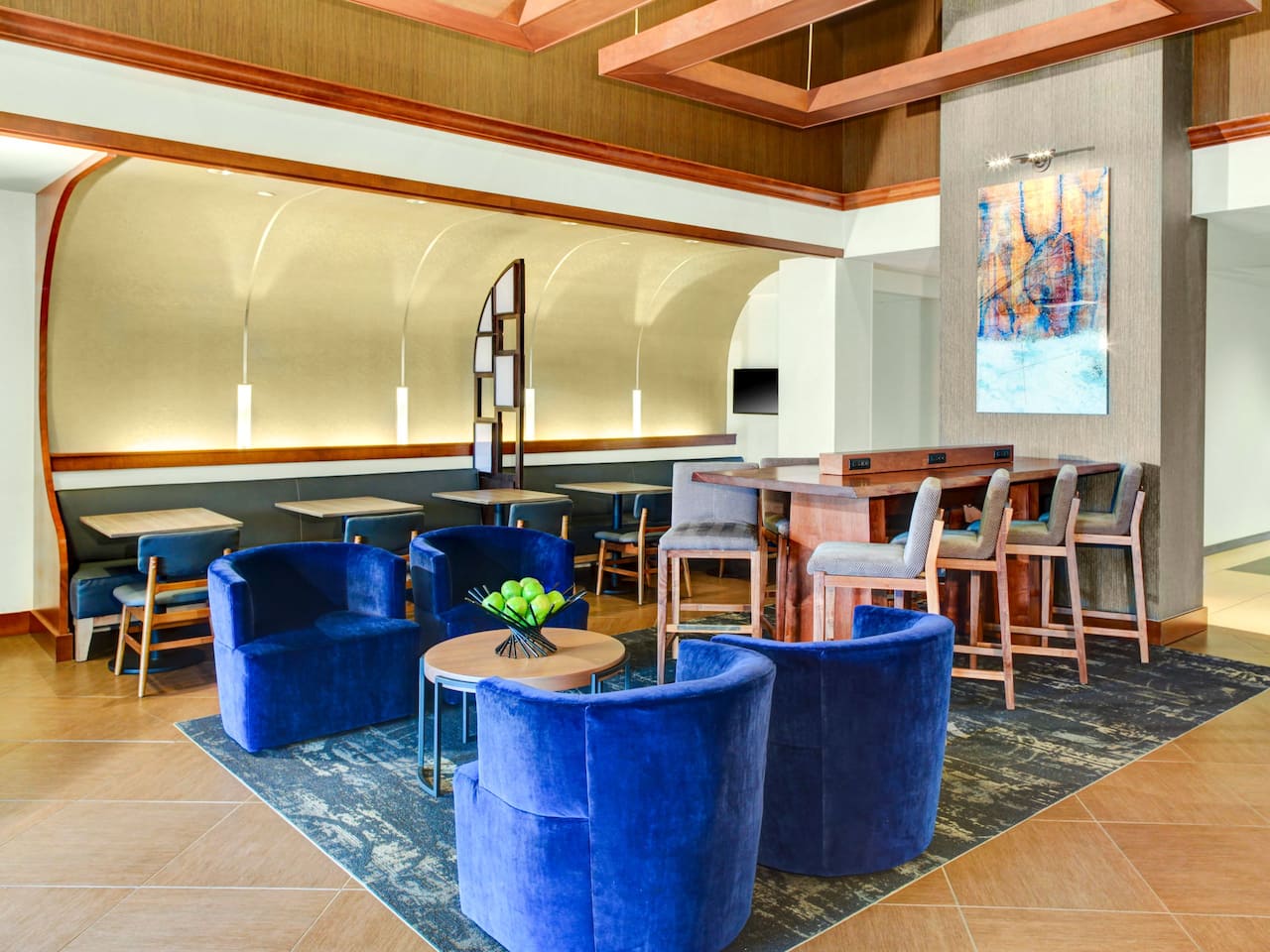 Lobby seating area with chairs, tables, and painting at Hyatt Place Detroit / Auburn Hills 