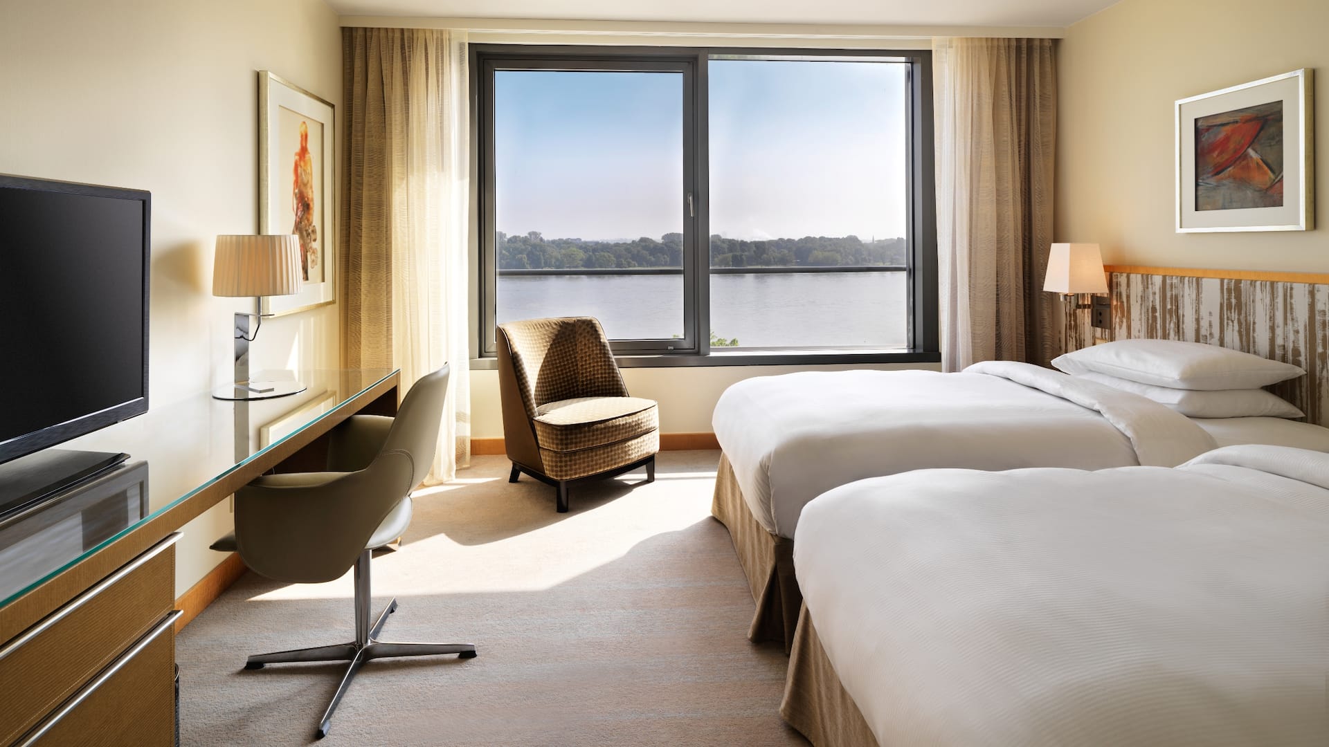 1 de 5 Ein großzügiges Zimmer mit zwei separaten Betten, einem geräumigen Schreibtisch und Ausblick auf den Rhein im Hyatt Regency Mainz Hotel.