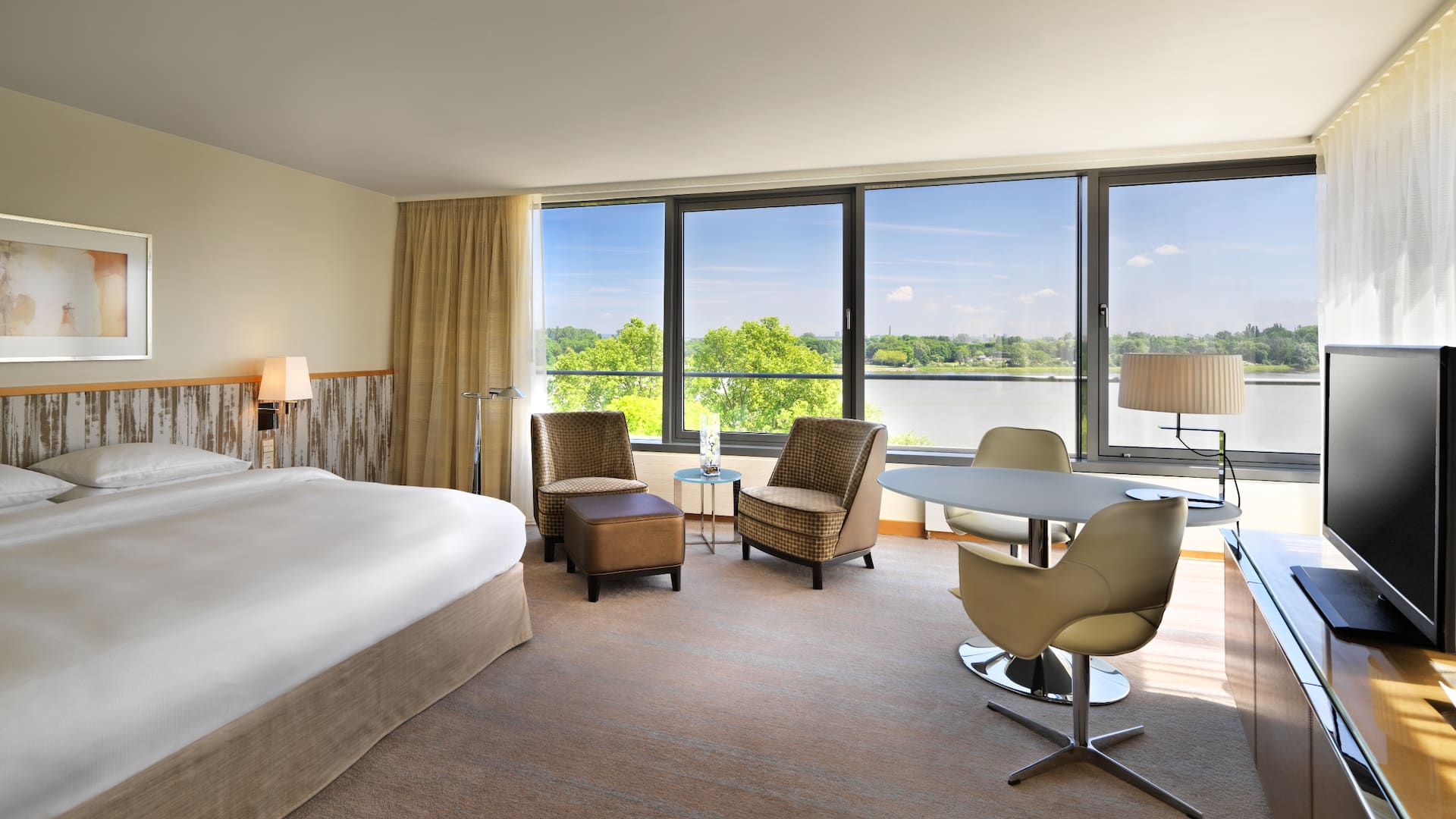 Spacious deluxe room at Hyatt Regency Mainz with large window front and stunning views of the Rhine river