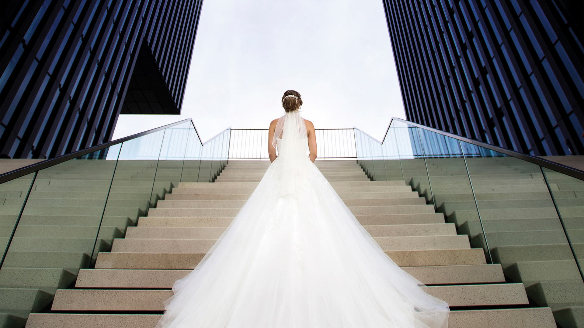 Bride with a white long dress stands on the stairs outside at the Hyatt Regency Dusseldorf