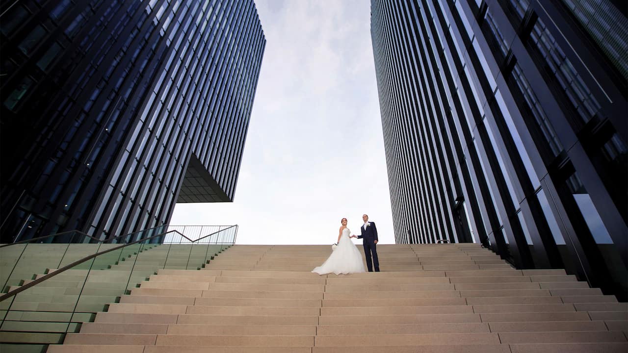 Wedding couple poses at hydraulic staircase of Hyatt Regency Dusseldorf