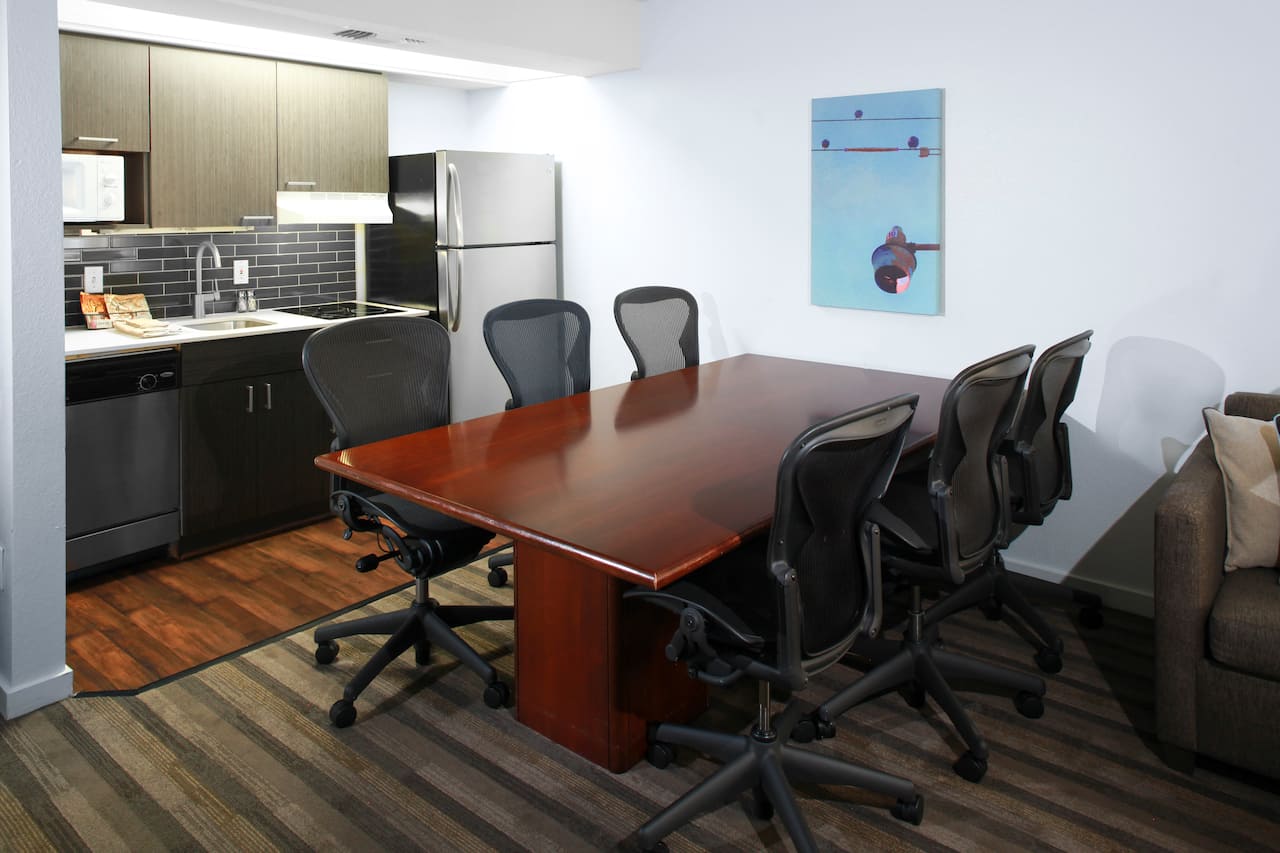 Fully equipped kitchen area with conference style table with six swivel chairs.
