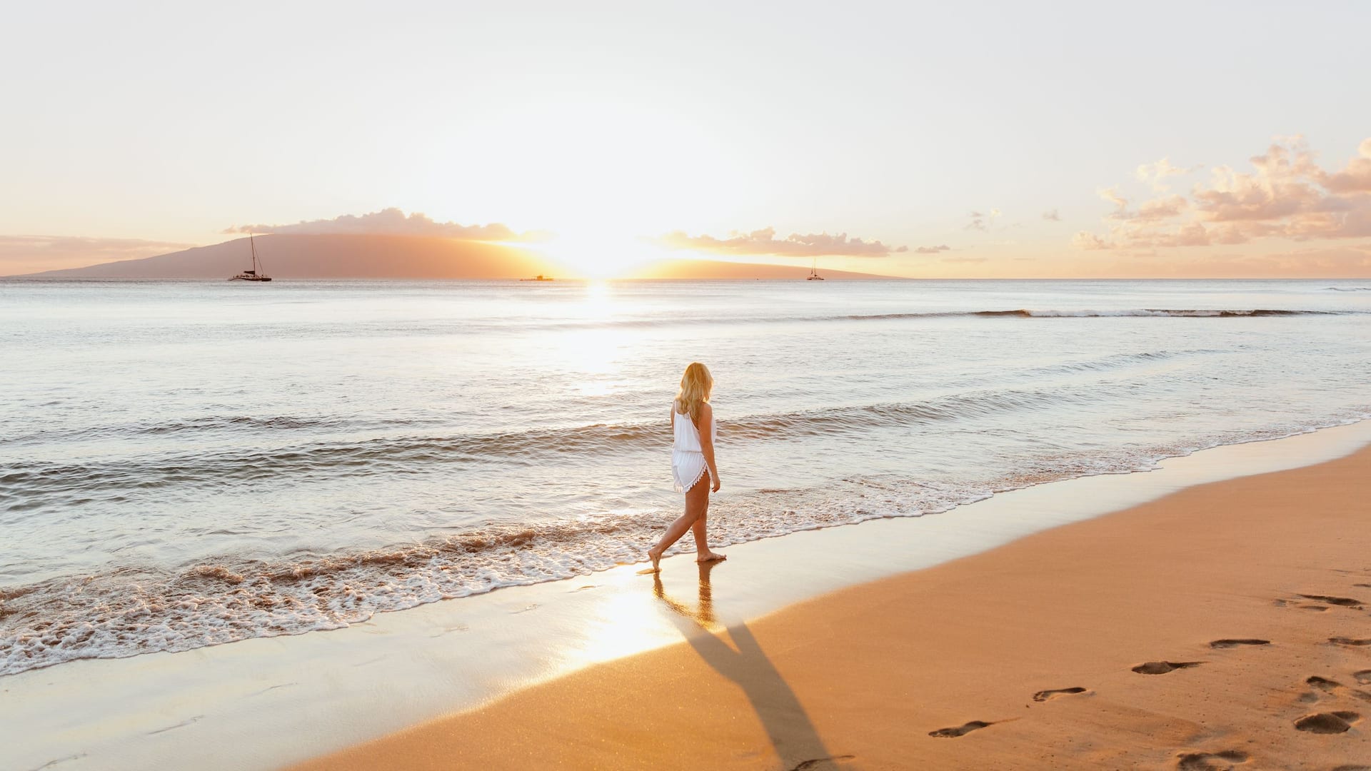 Woman walking the beach at sunset near Hyatt Regency Maui Resort and Spa