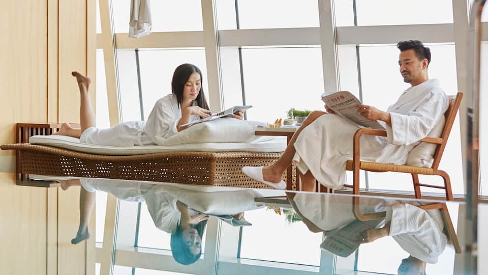 Couple relaxing by the pool in bathrobes