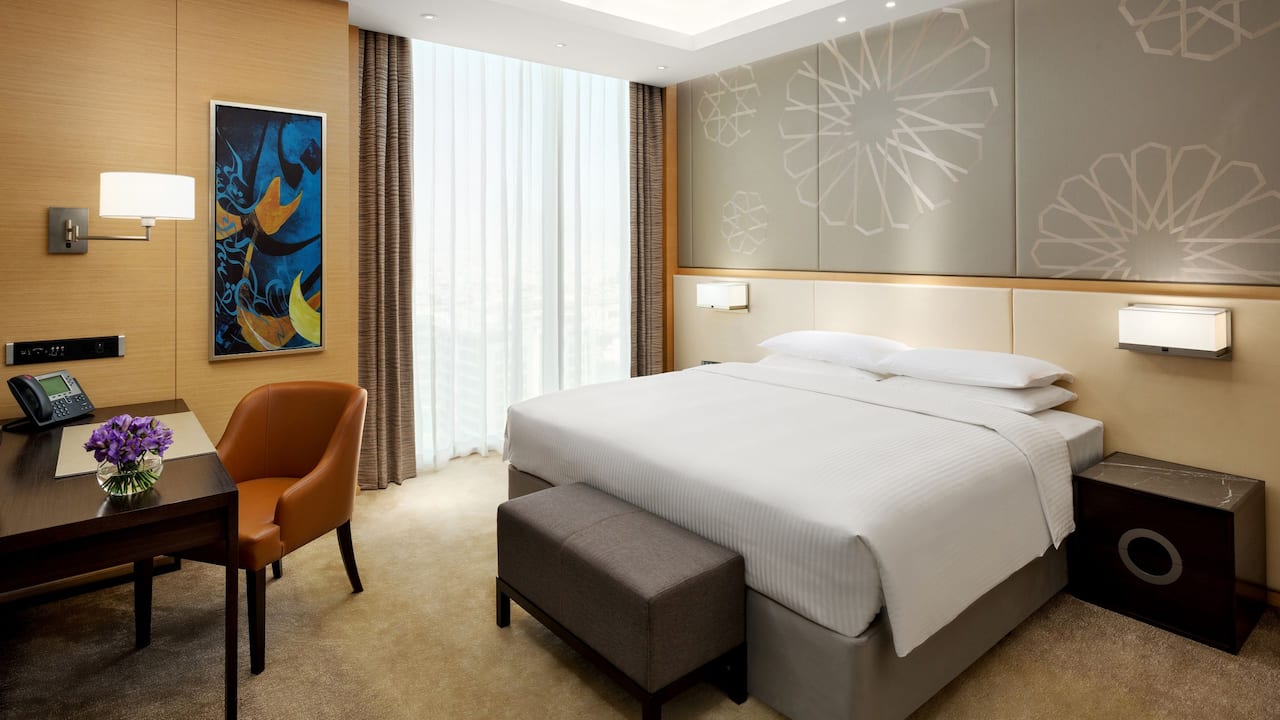 King-sized bed by large window in hotel room