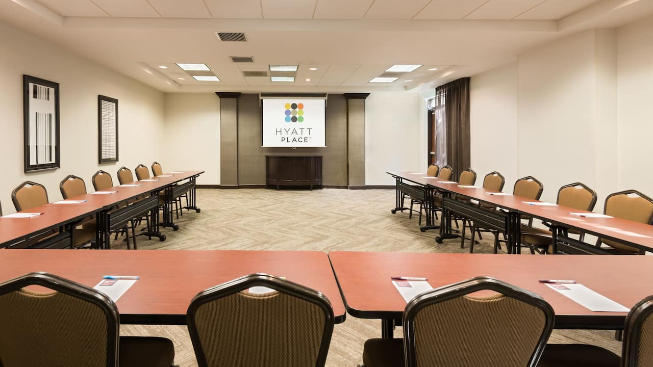Large meeting room with U-shape setup and projector screen