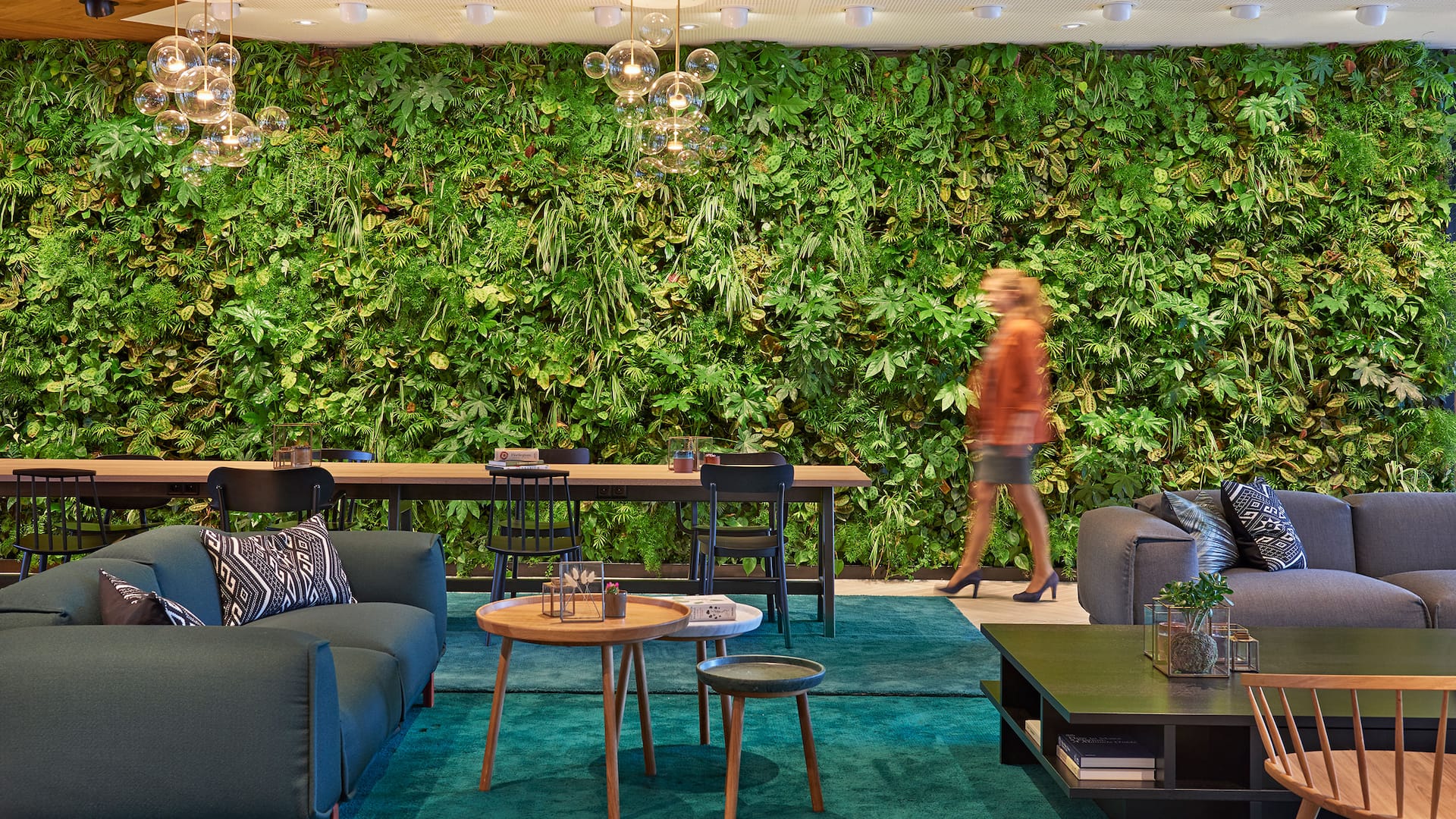 A close-up of a seating area at restaurant Mama makan with green booths and plants in woven baskets