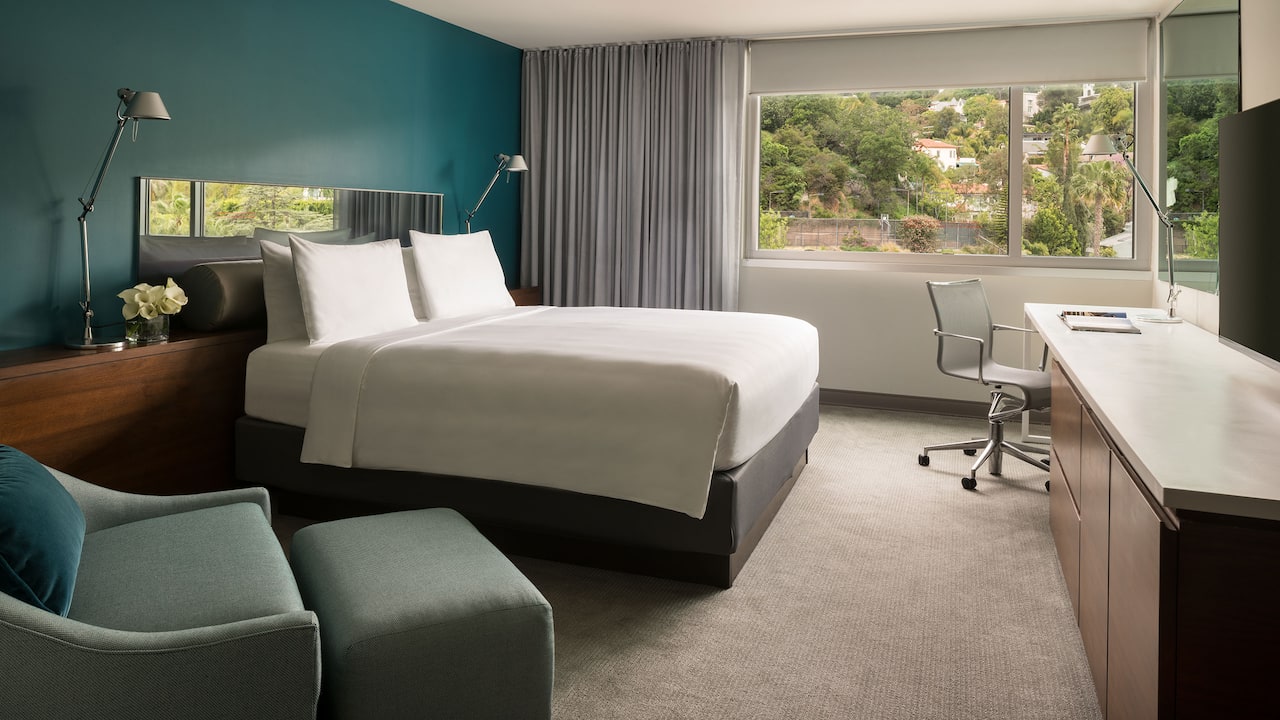 An ADA compliant hotel room with a king bed and views of the West Hollywood Hills