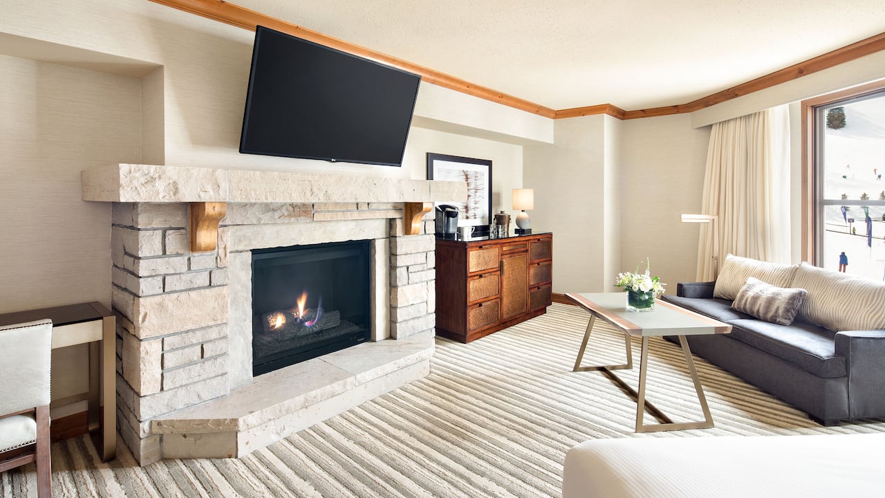 Park Fireside Suite living area with fireplace, wall-mounted television, sofa and coffee table