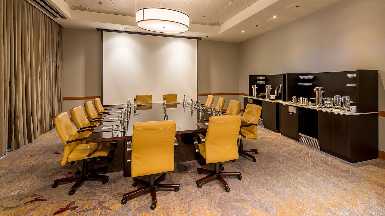 Conference Center with large table, projector screen and coffee station