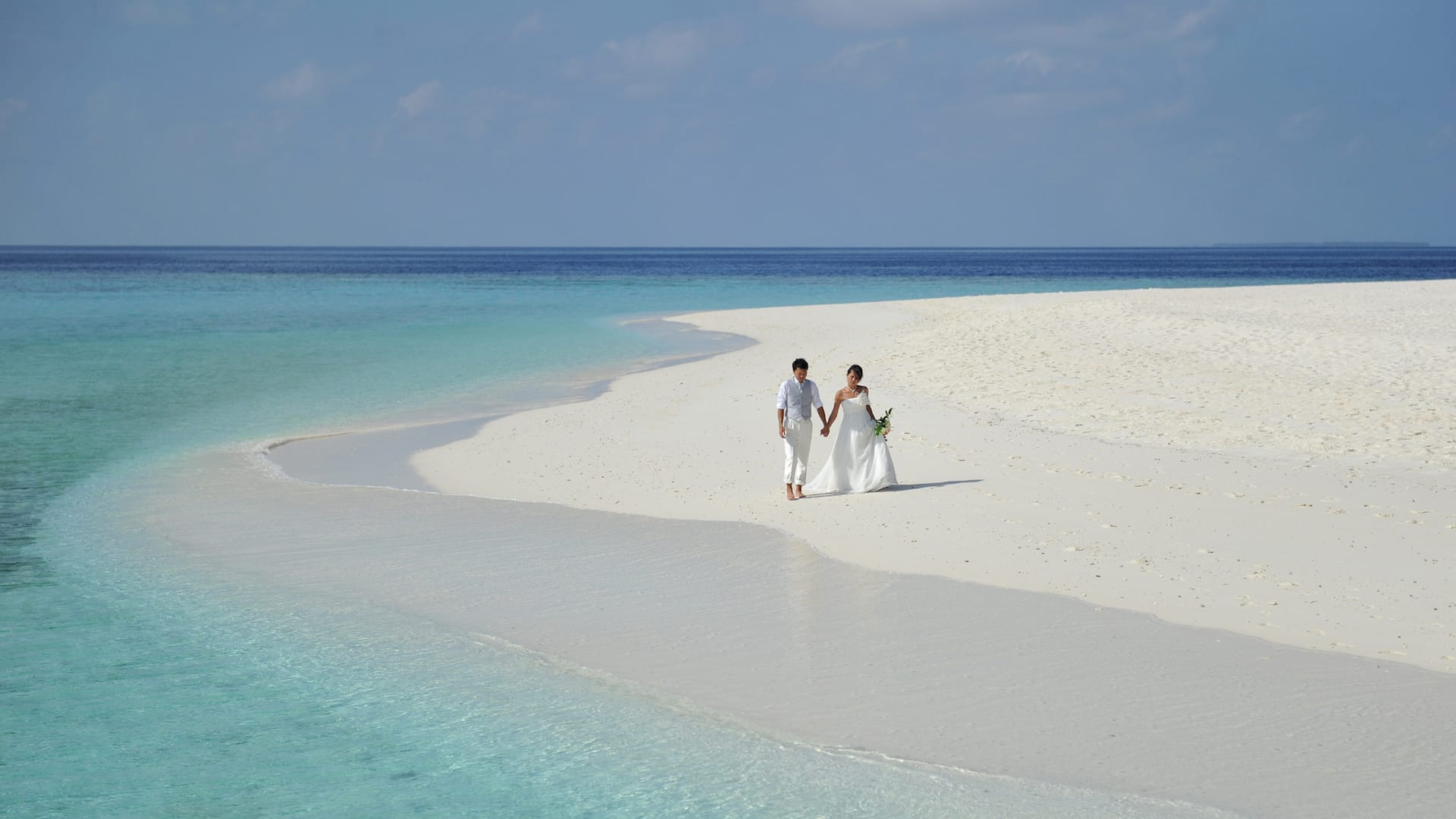 maldives honeymoon package couple walking on the ocean
