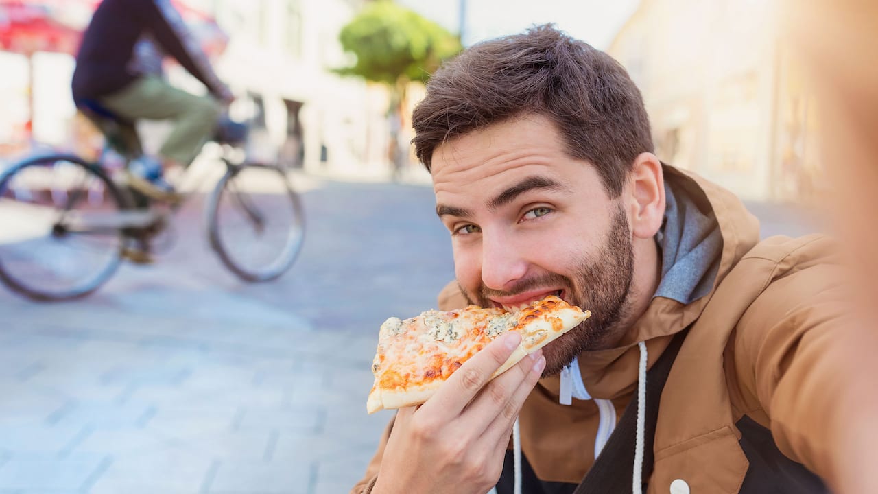 Man eating pizza near Hyatt Centric Fisherman's Wharf