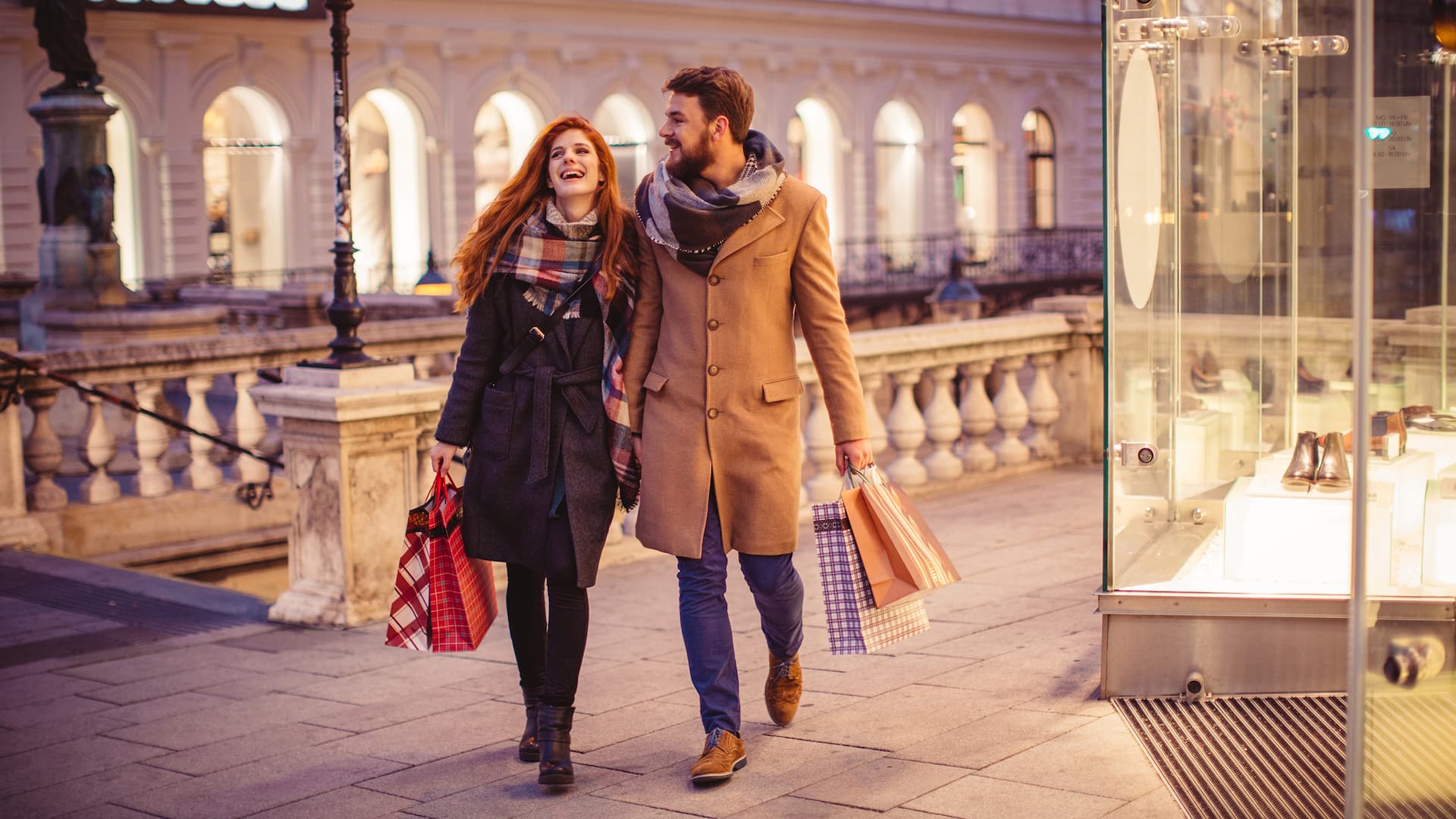 Two guests, are shopping in the city and walking happily down the street