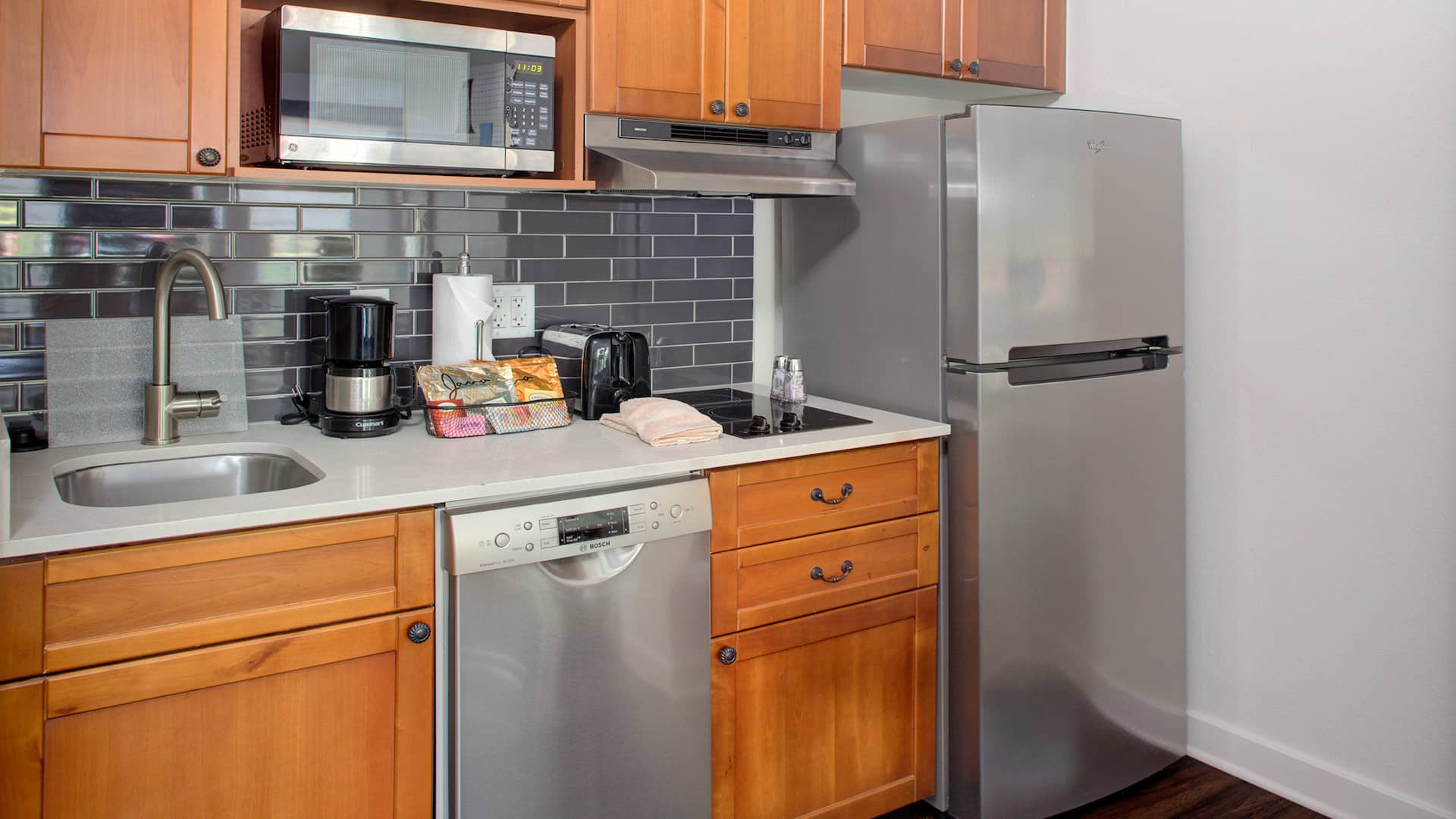 Extended stay kitchen with fridge, dishwasher, microwave, sink, toaster, and stove at Hyatt House Parsippany East