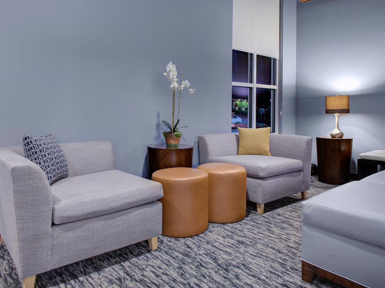 Lobby seating area with couch, lamps, and coffee table at Hyatt House Shelton
