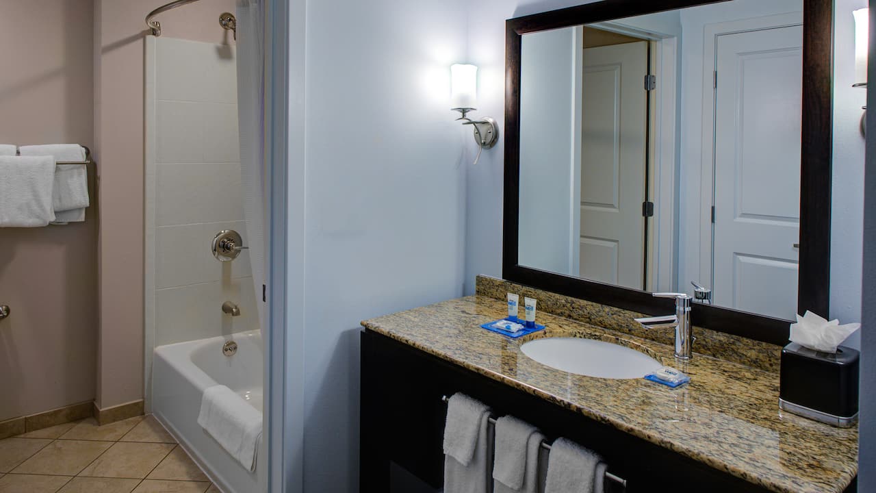 Extended stay guest room bathroom sink and mirror with shower/tub combo at Hyatt House Shelton