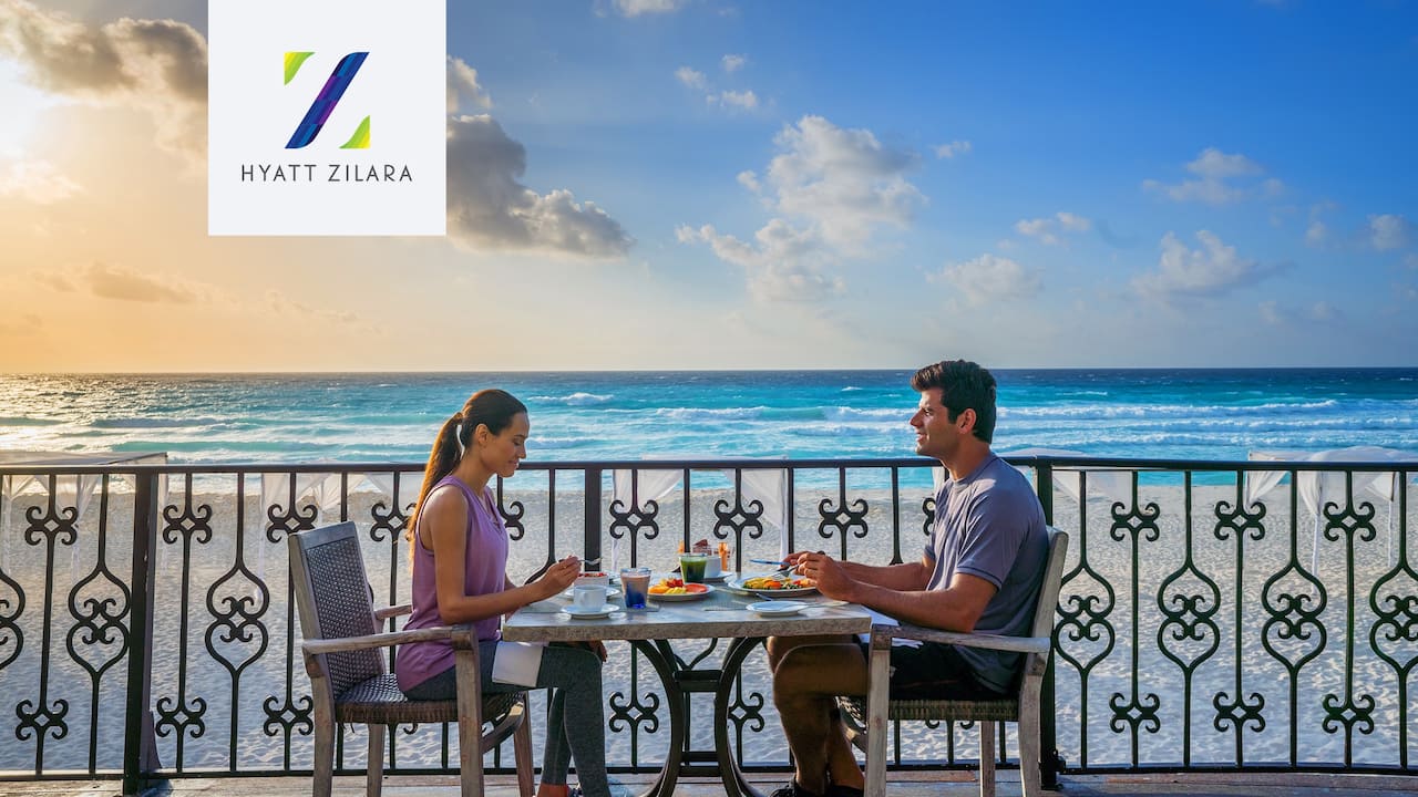 Couple eating oceanside at Hyatt Zilara Cancun