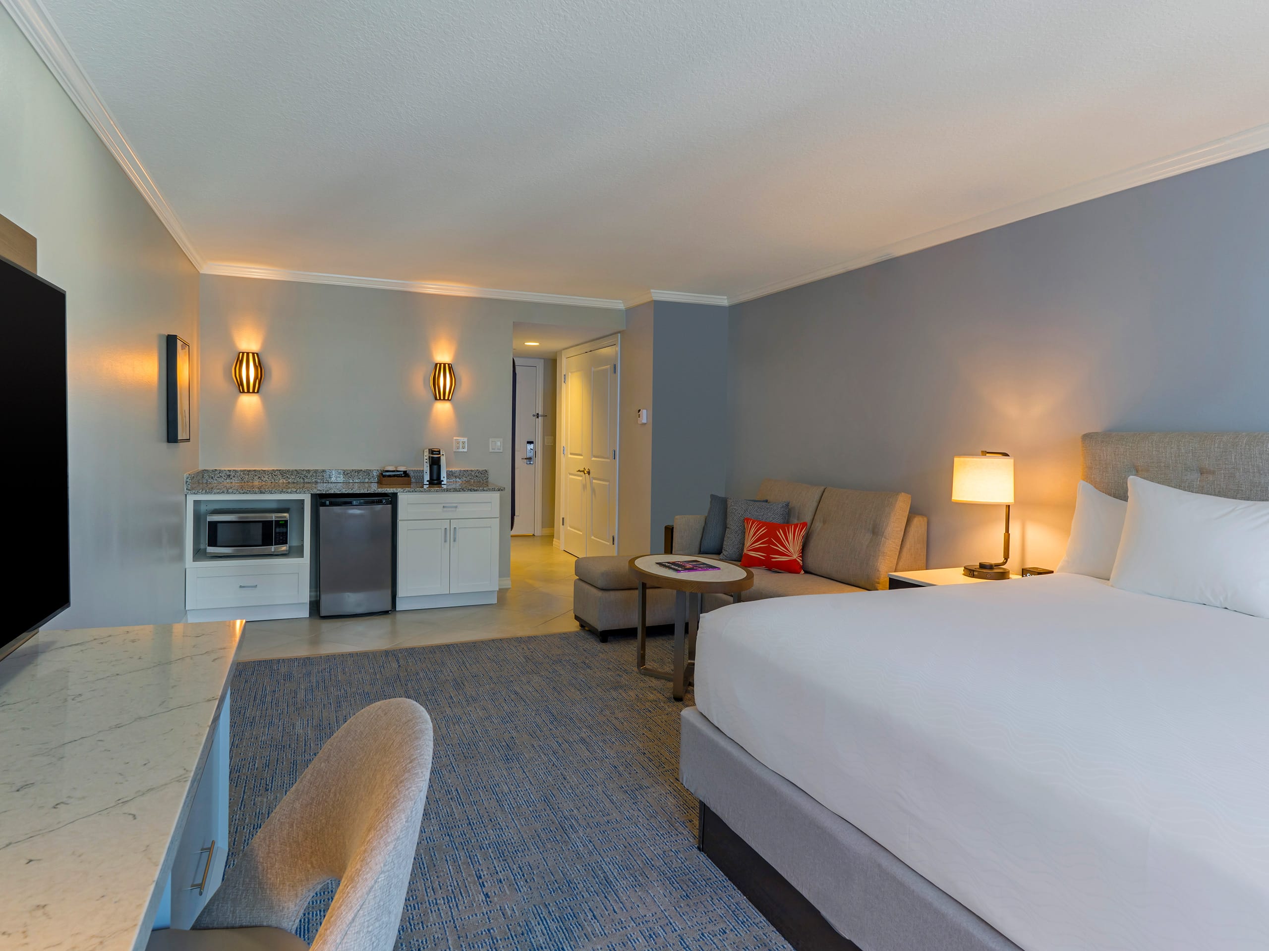 King-sized bed, TV and mini-kitchen in hotel room