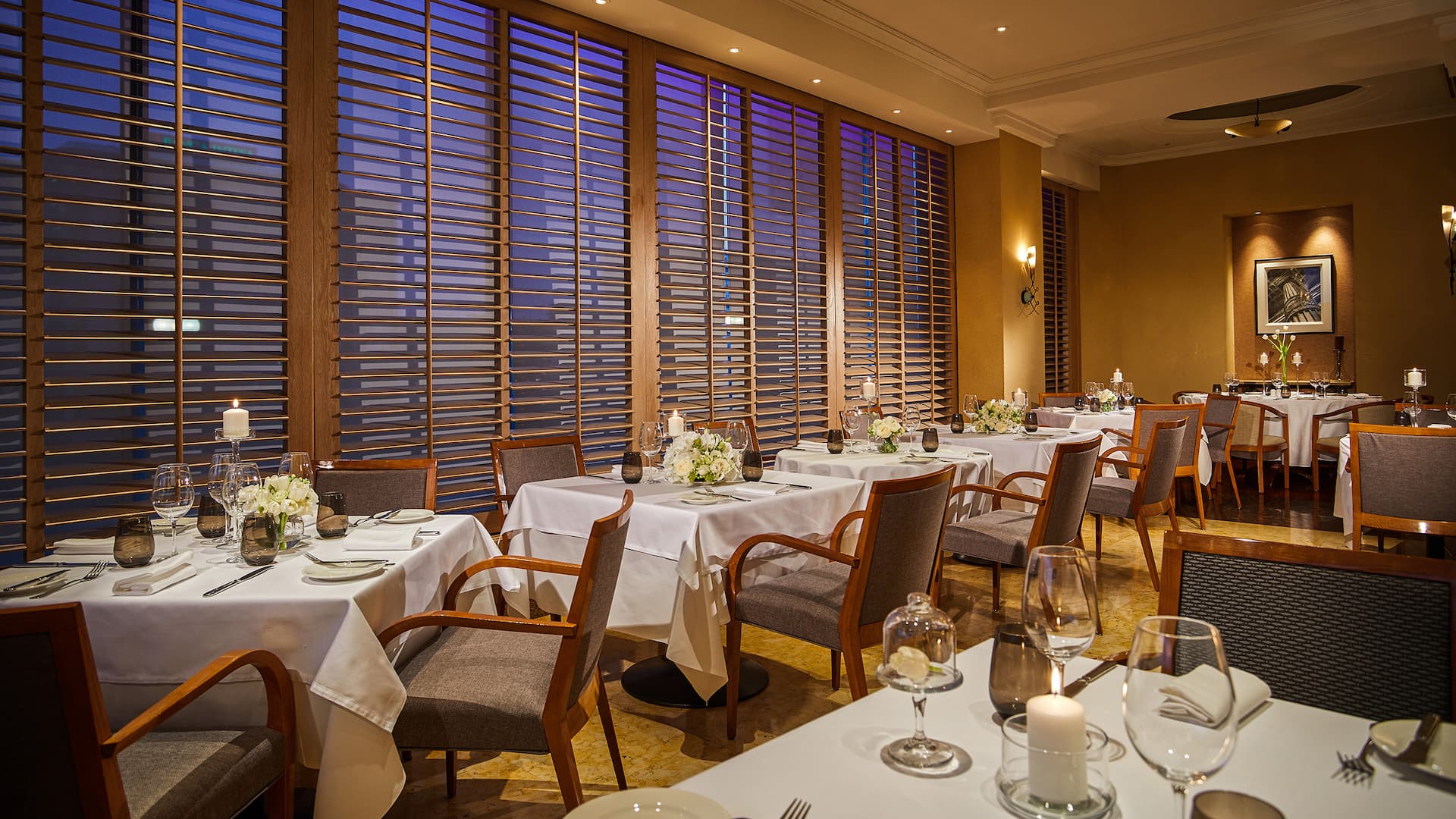 1 of 1 Elegant dinner setting at Metropolitan restaurant with stylish tables, ambient lighting, and a sophisticated atmosphere.